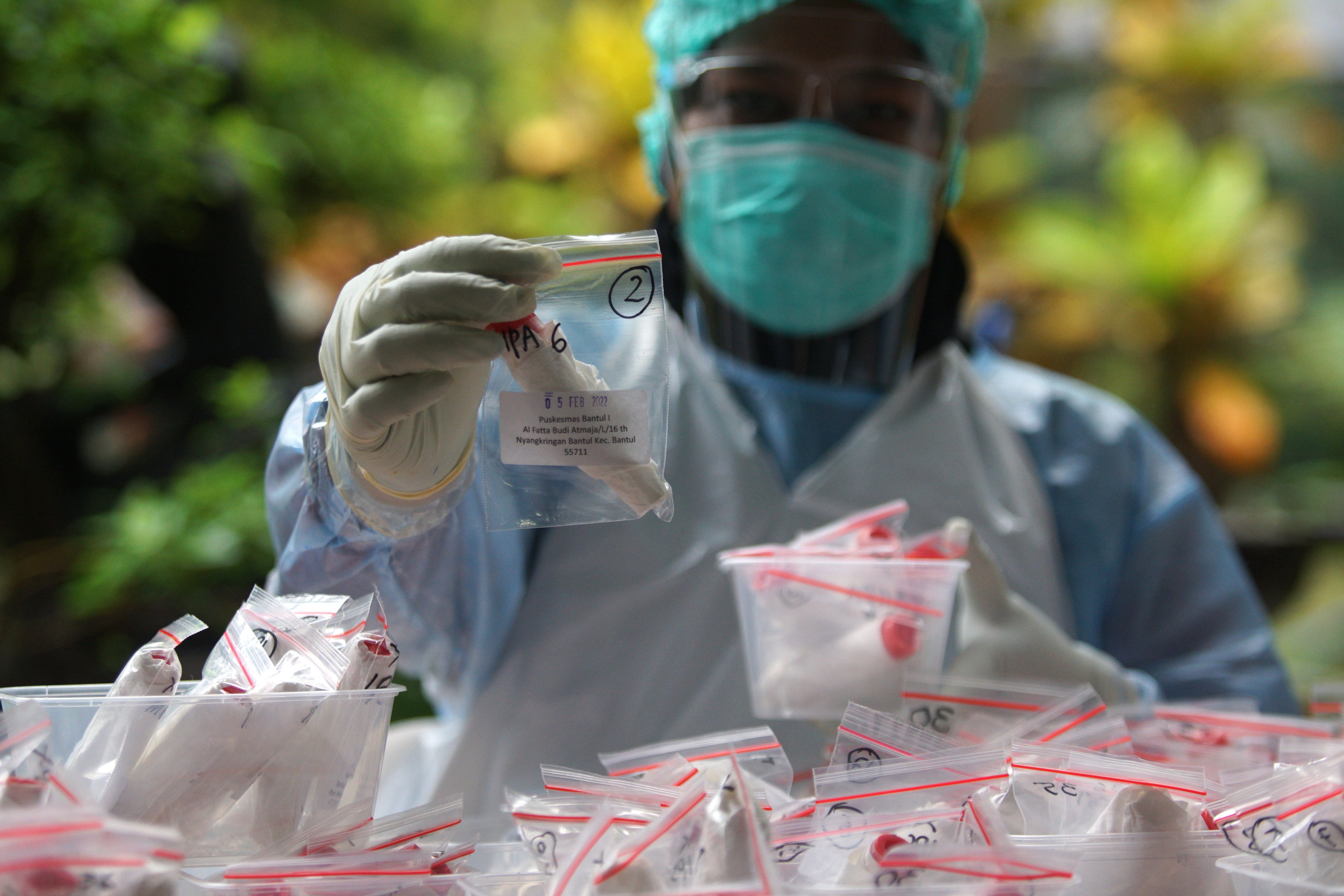 Petugas kesehatan menunjukkan sampel tes Swab PCR COVID -19