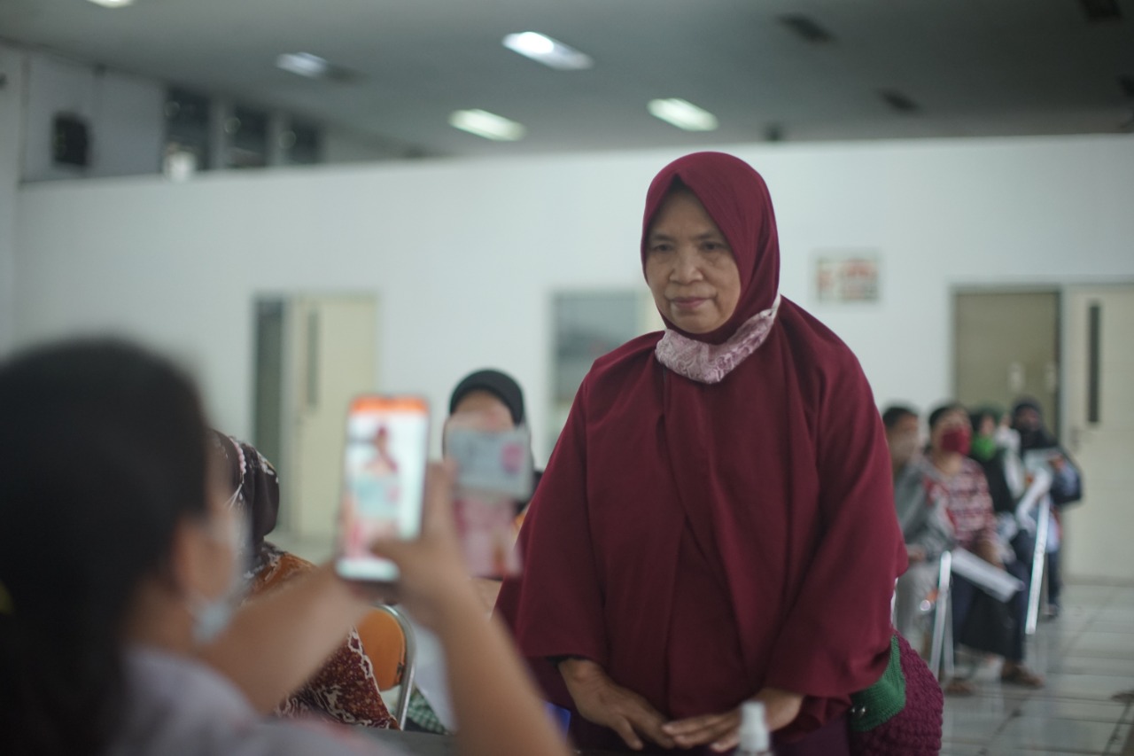 Seorang warga yang menerima dana sosial sembako dari Kemensos dipotret di Kantor Pos Indonesia. 