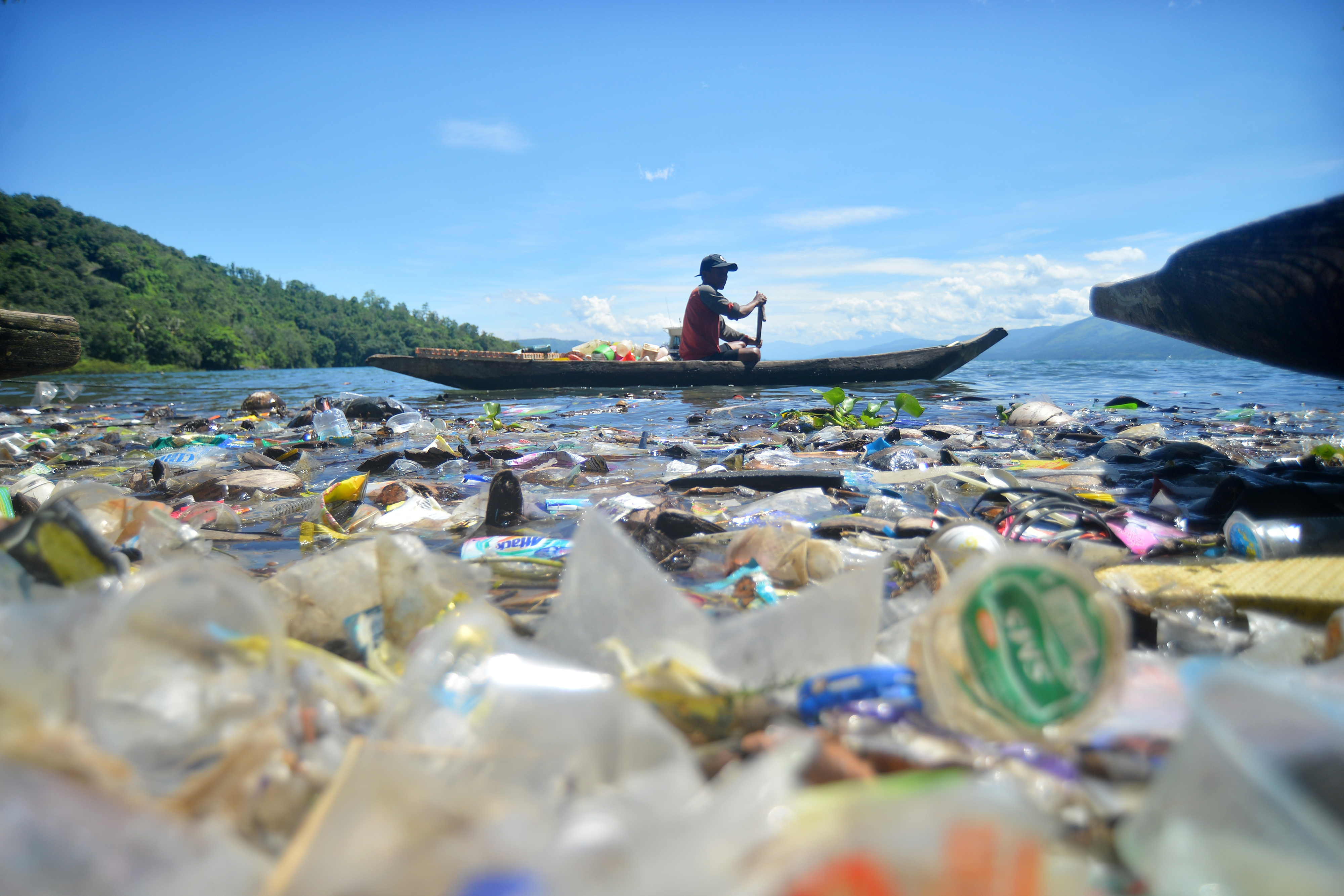 Nelayan mengayuh biduk di antara sampah yang mengotori Danau Singkarak, Sumatera Barat.