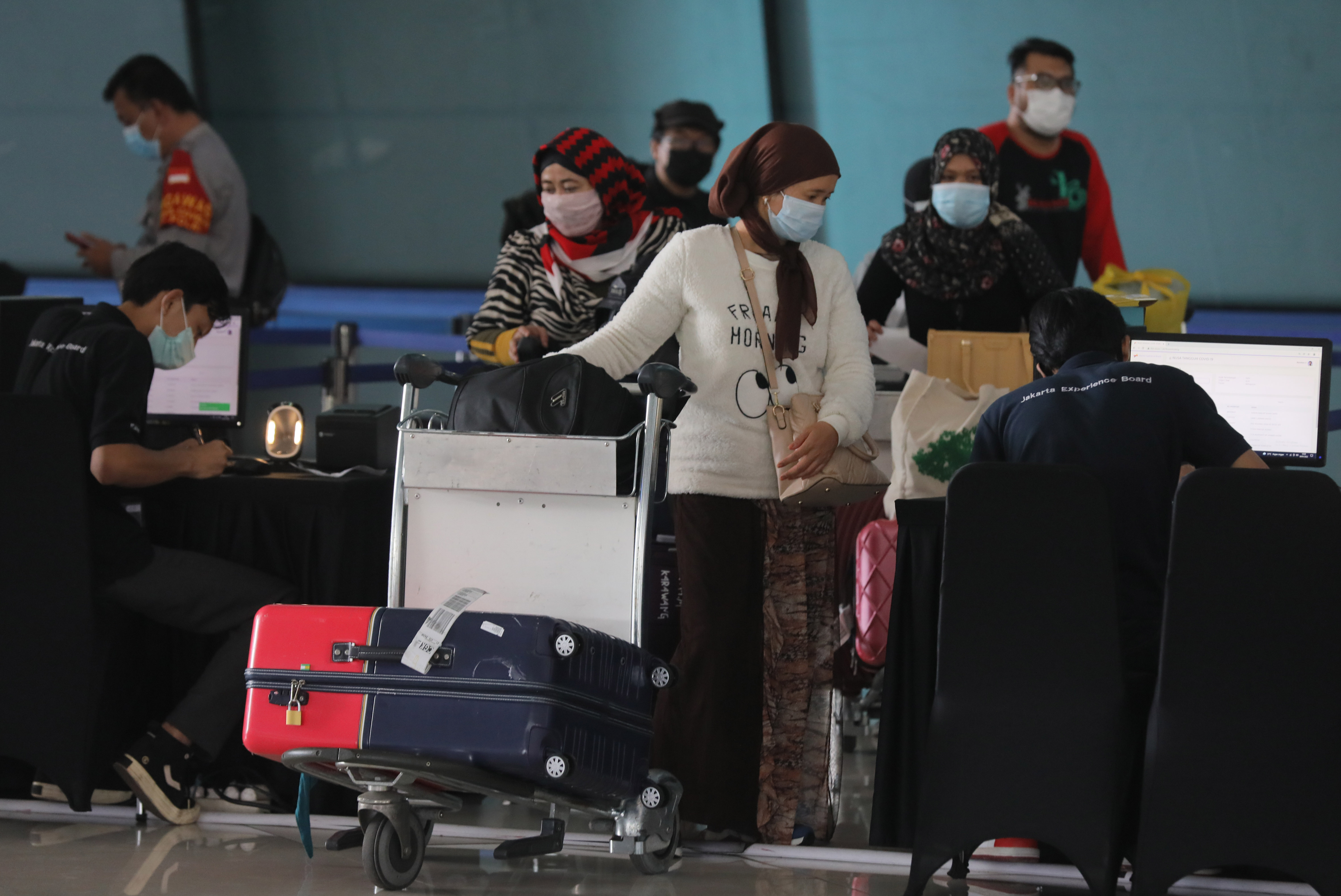 Petugas memeriksa Pekerja Migran Indonesia (PMI) yang tiba  di Terminal 3 Bandara Internasional Soekarno Hatta, Tangerang.
