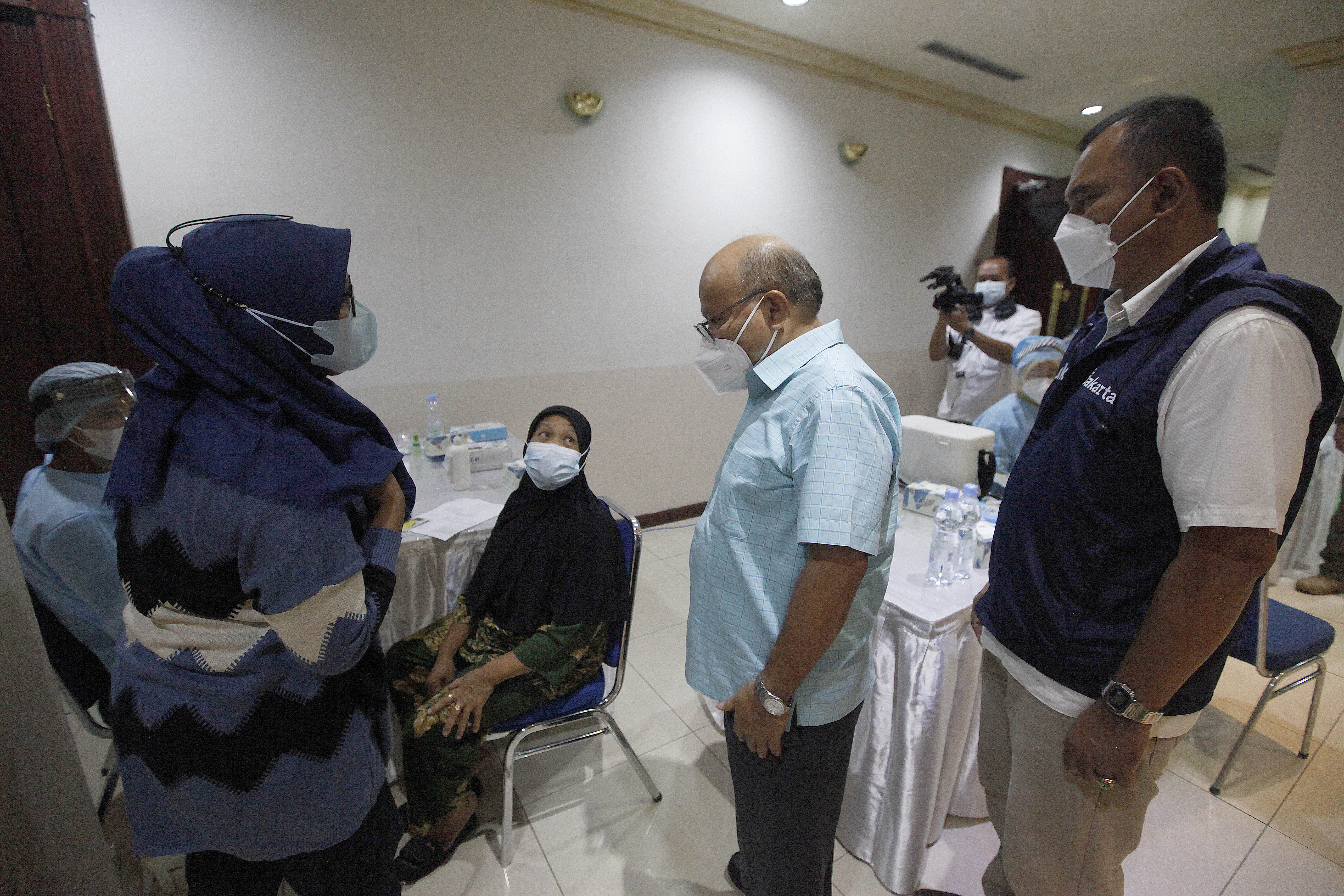 Vice President News and Media, Media Group, Don Bosco Selamun berbincang dengan warga sekitar di sentra vaksinasi booster Covid-19.