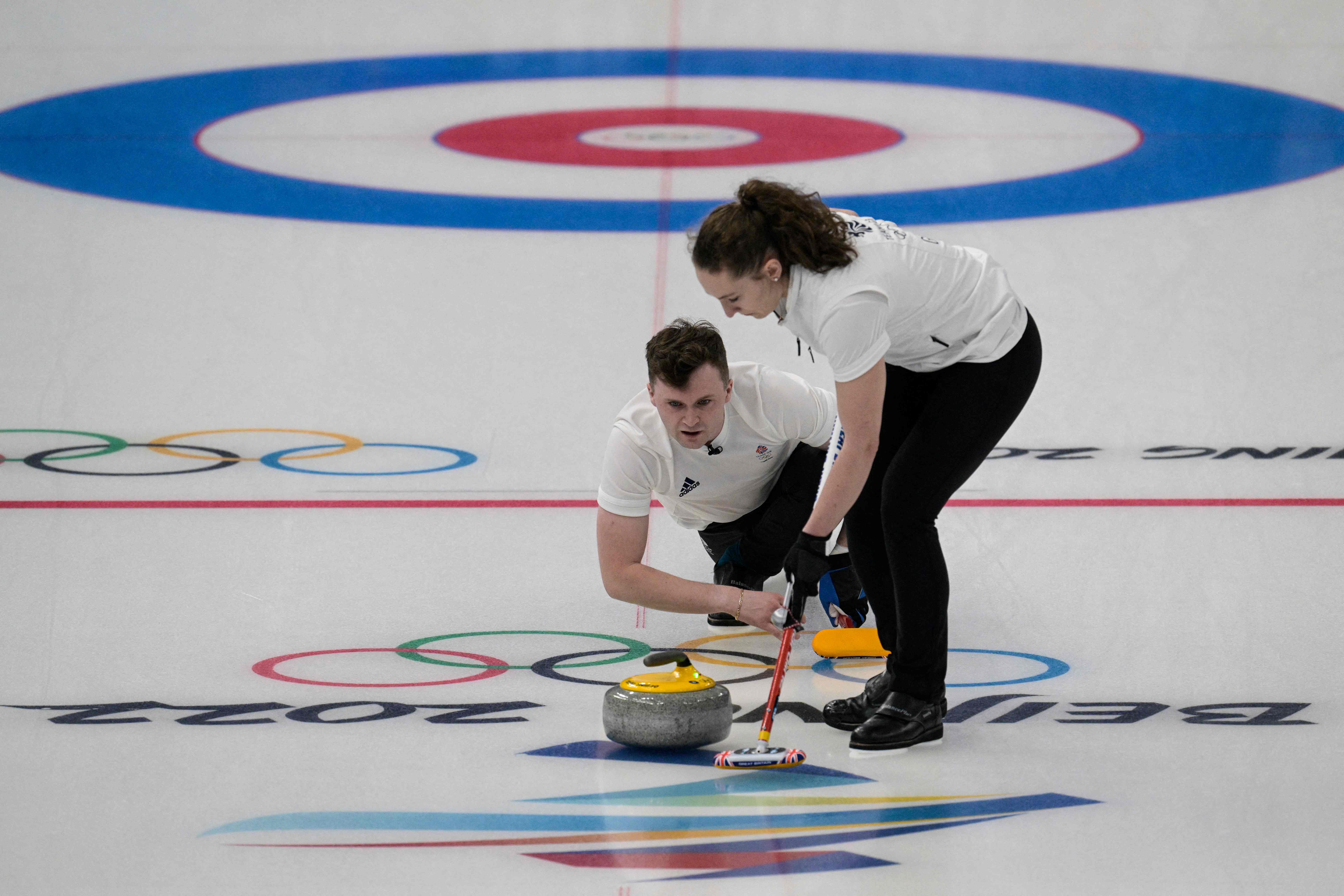 Aksi duet Inggris Bruce Mouat dan Jennifer Dodd di nomor ganda campuran curling di Olimpiade Beijing 2022.