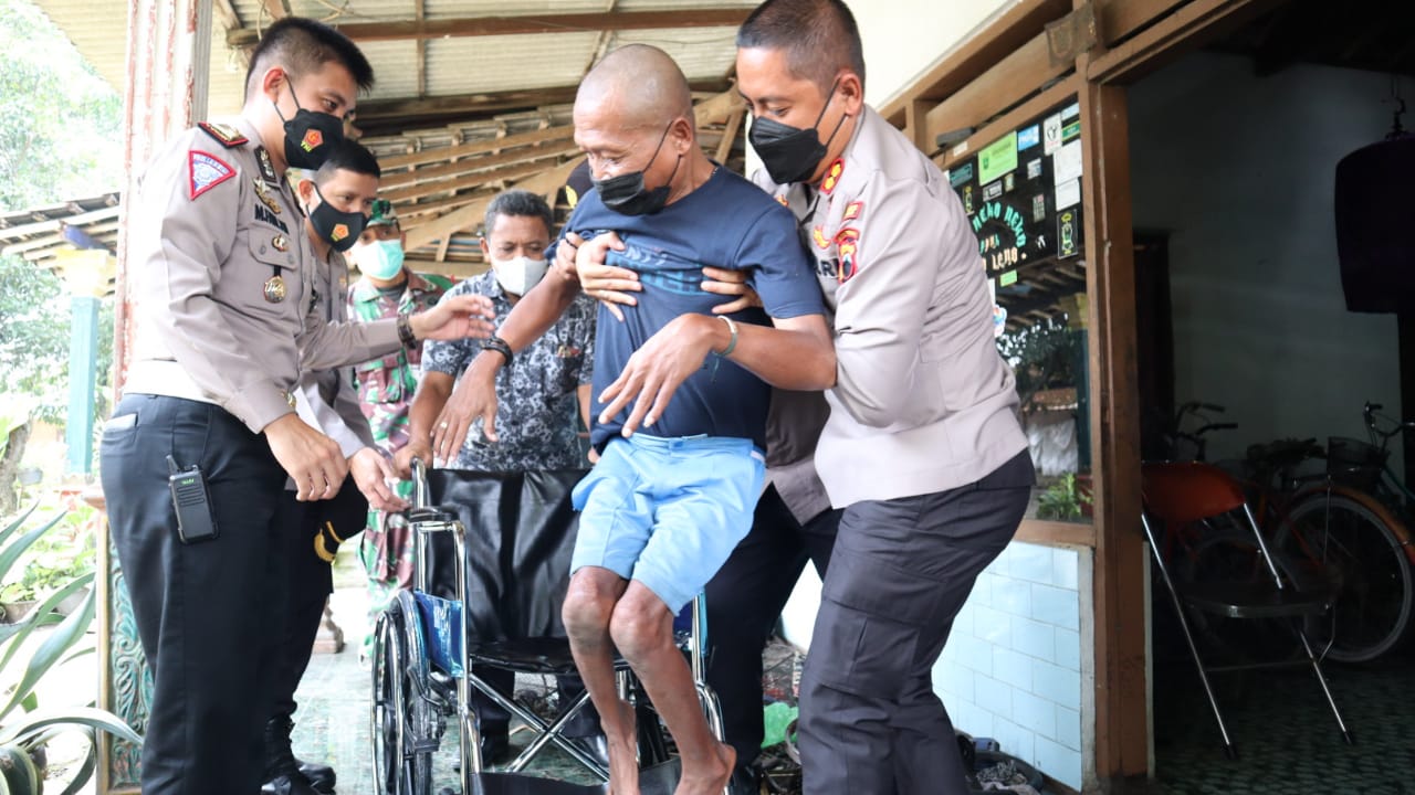 Kapolres Klaten AKB Eko Prasetyo membantu Abdul Rochman naik ke kursi roda baru