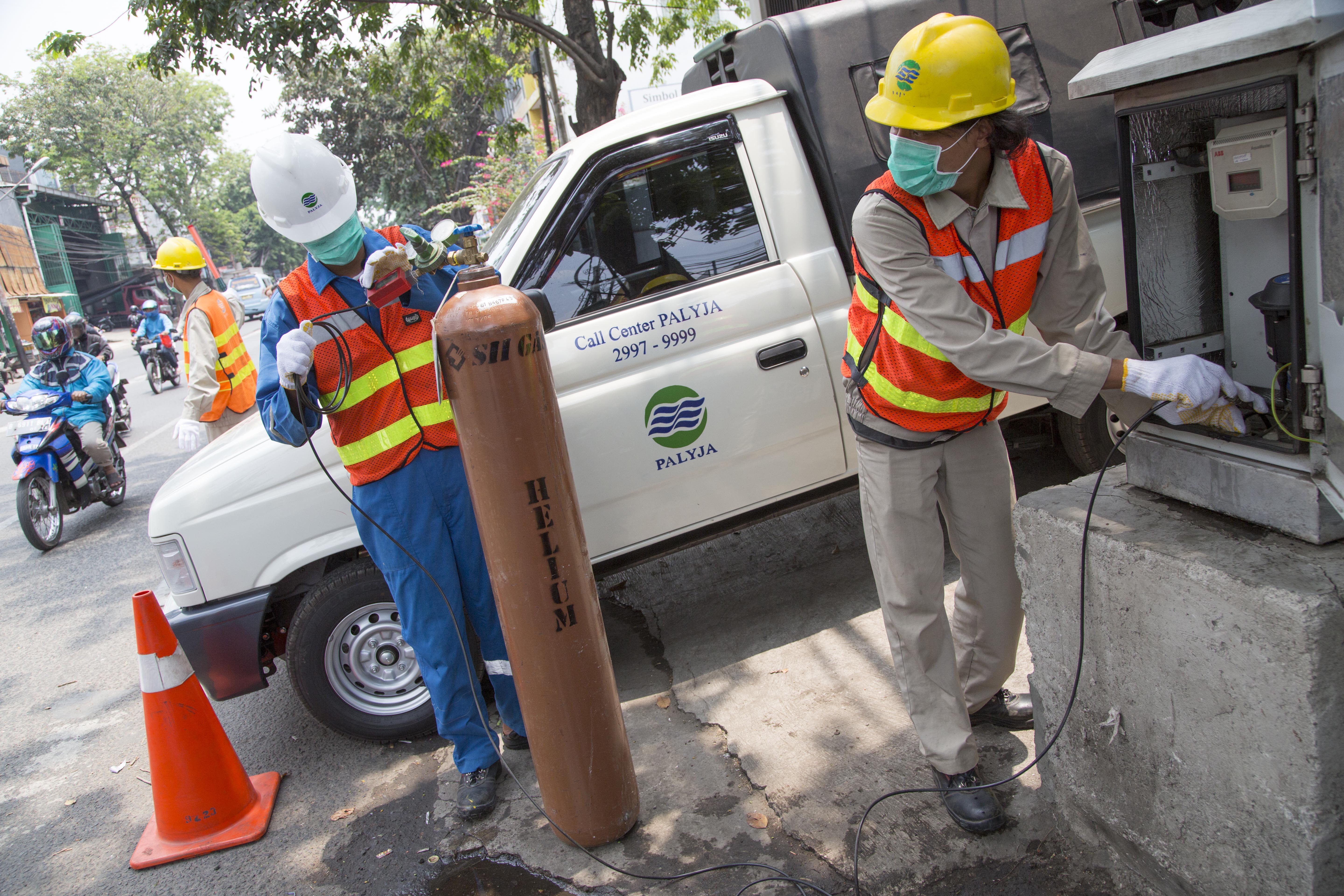 Petugas Petugas melakukan injeksi gas helium di gardu pemantau aliran air di kawasan Jembatan Lima, Jakarta Barat, mengecek pipa yang bocor.