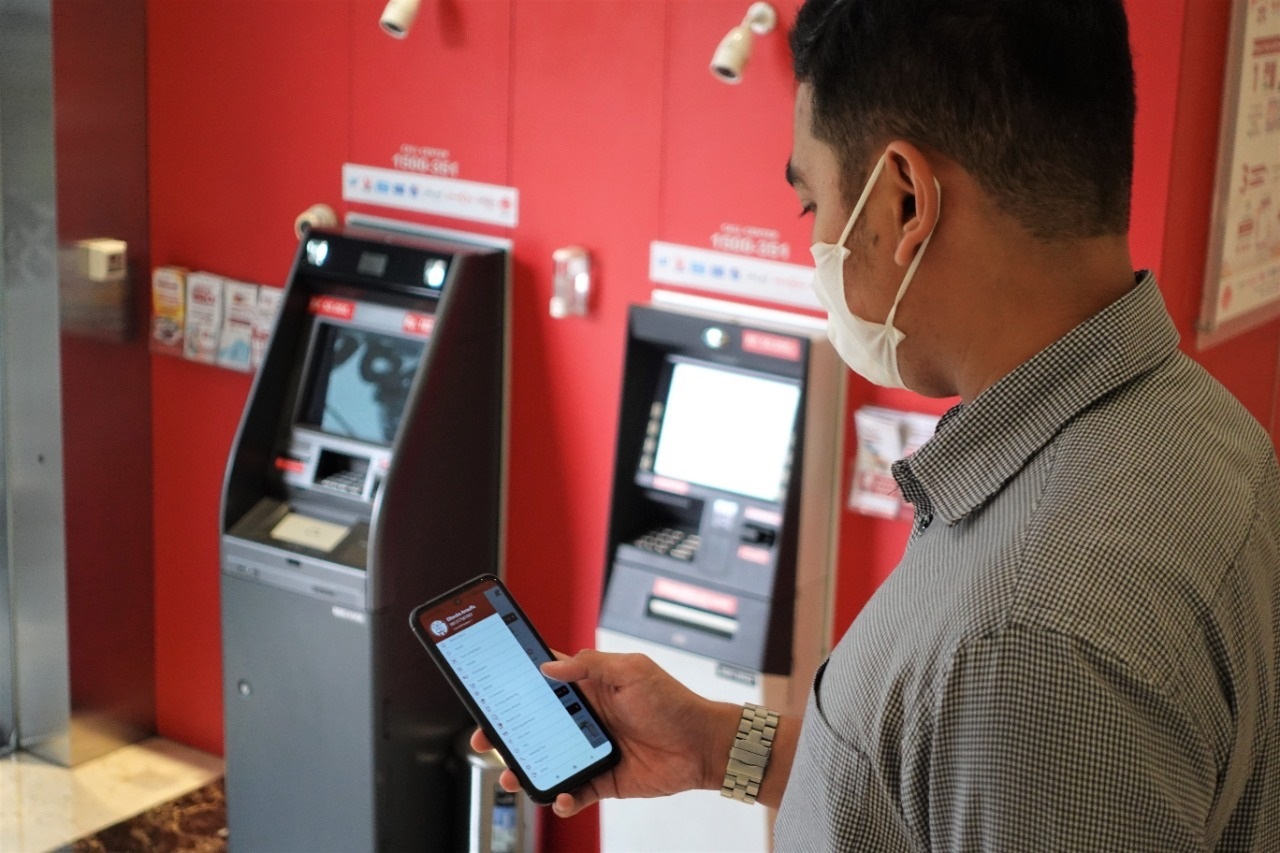 Nasabah memperhatikan aplikasi JakOne Mobile. 