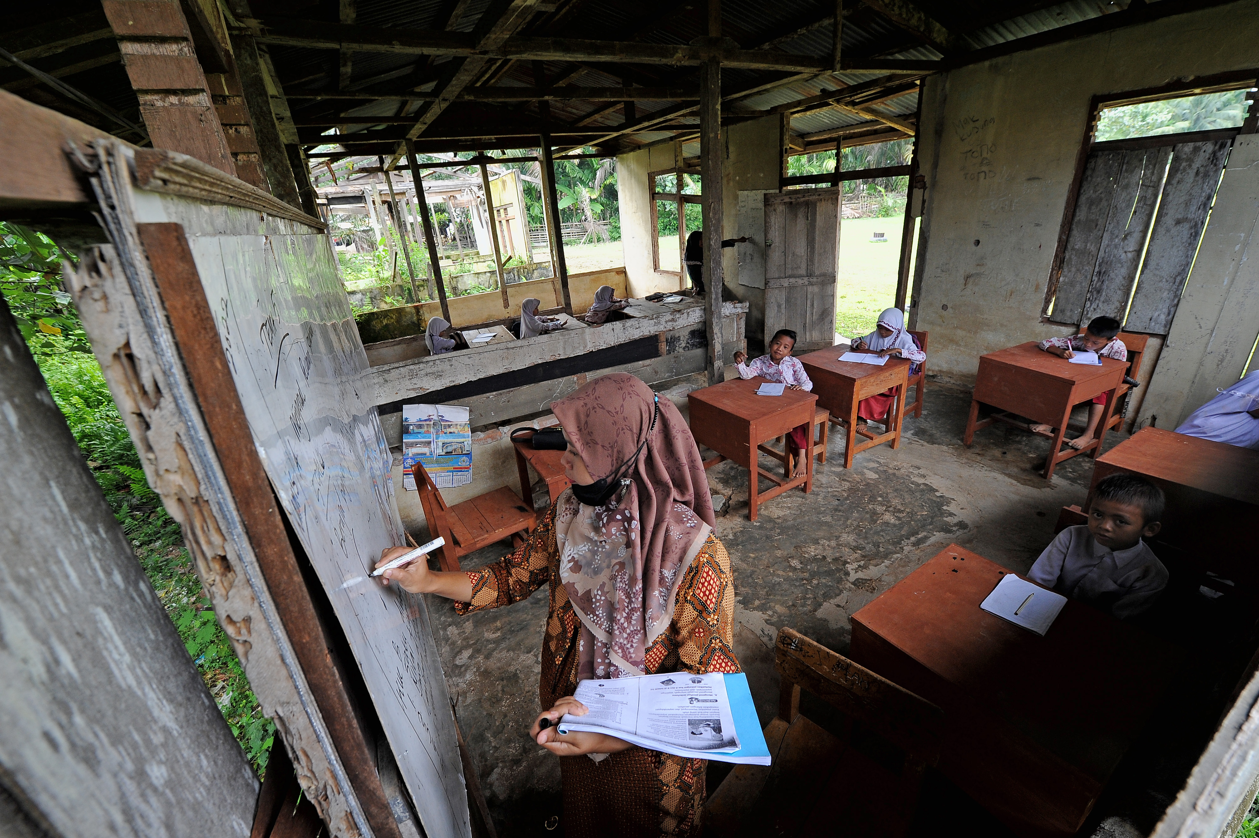 GURU MENGAJAR: Seorang guru tengah mengajar di kelas III SDN 217 Pamenang, Jambi. Peran guru di wilayah terpencil sangat dibutuhkan.