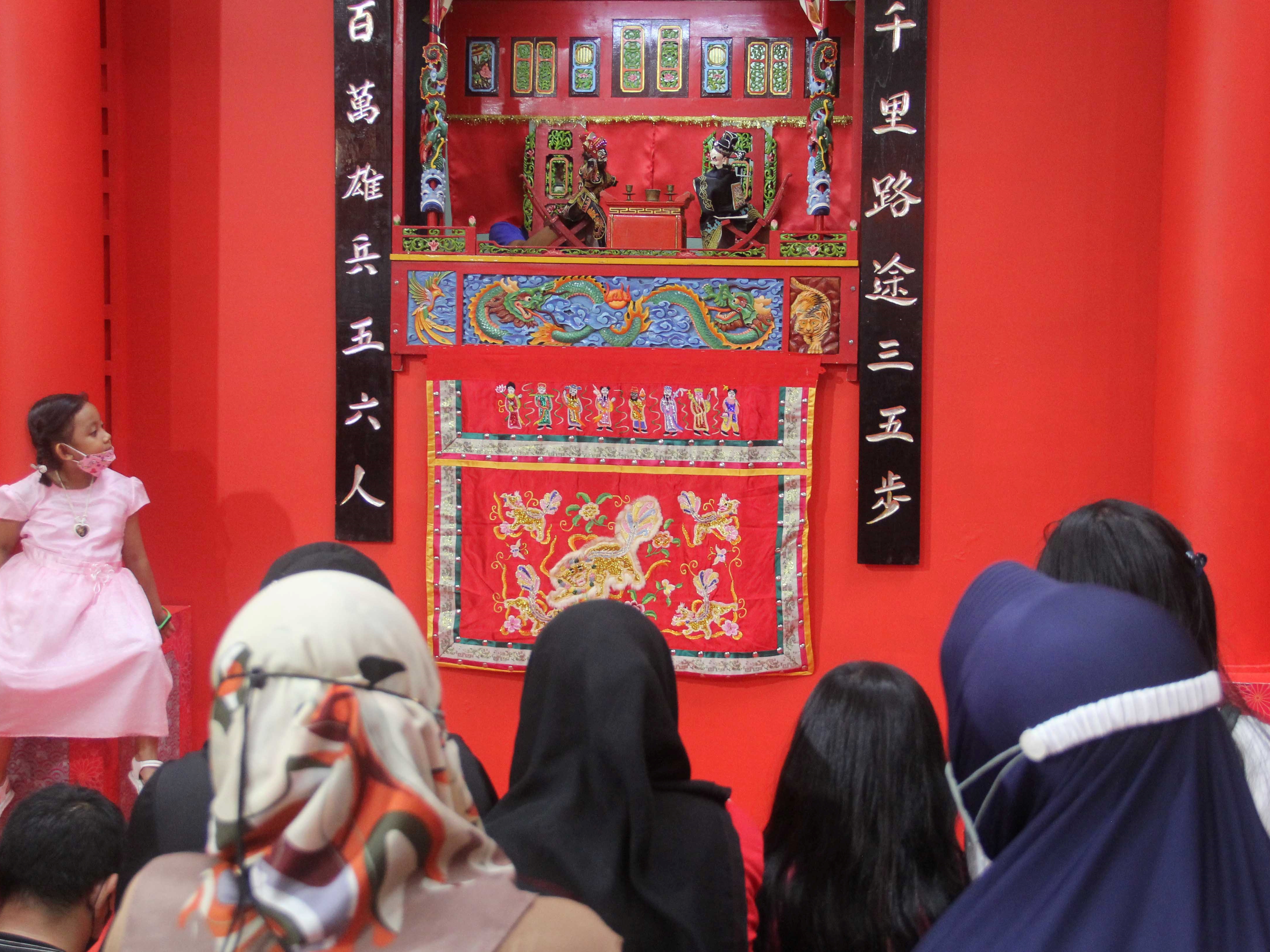 Anak pengunjung mal menyaksikan pertunjukan Wayang Potehi saat liburan Imlek di Ciputra Mall, Jakarta Barat, Selasa (1/2).