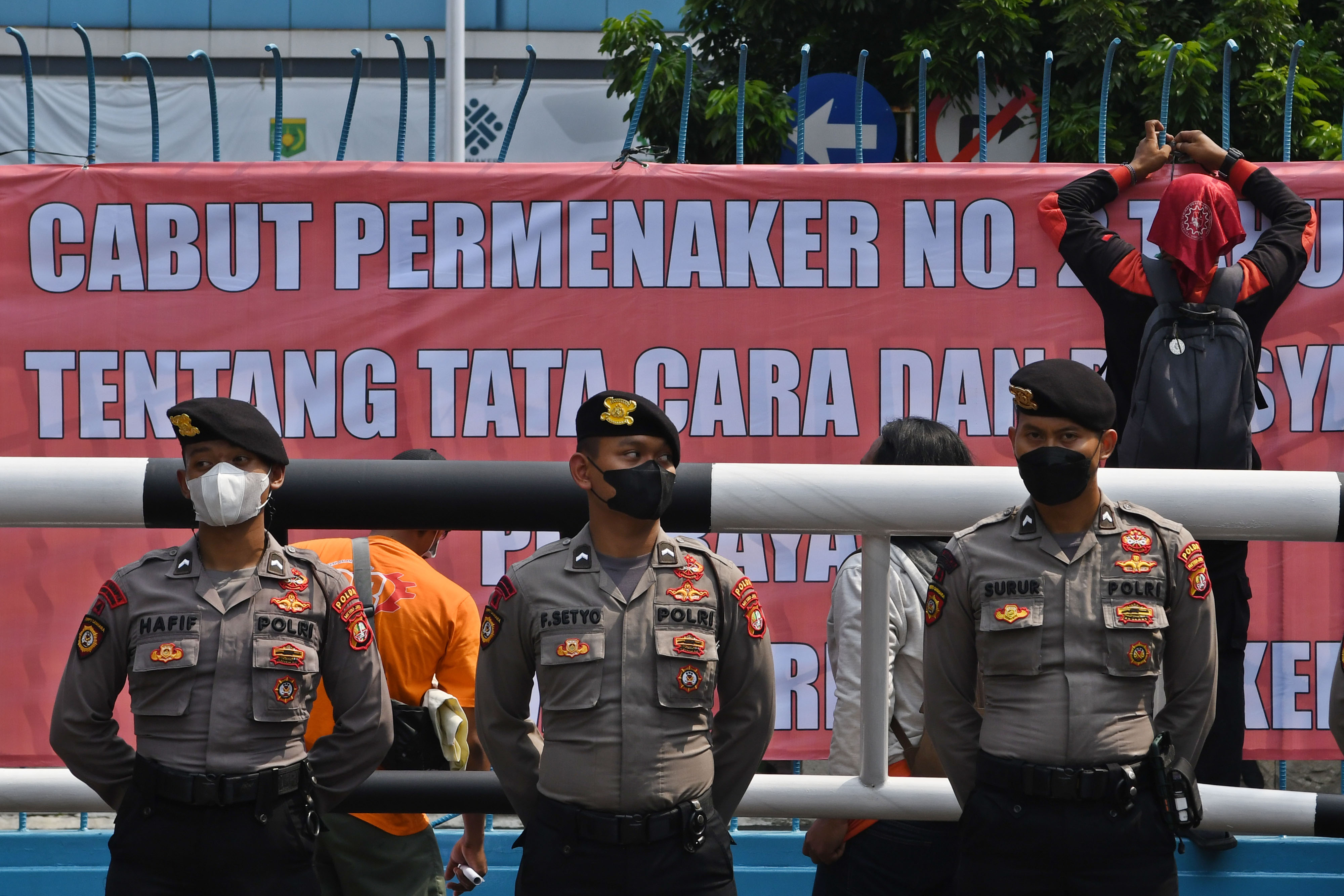 Buruh memasang spanduk saat berunjuk rasa di depan Kantor Kementerian Ketenagakerjaan (Kemnaker), Jakarta.
