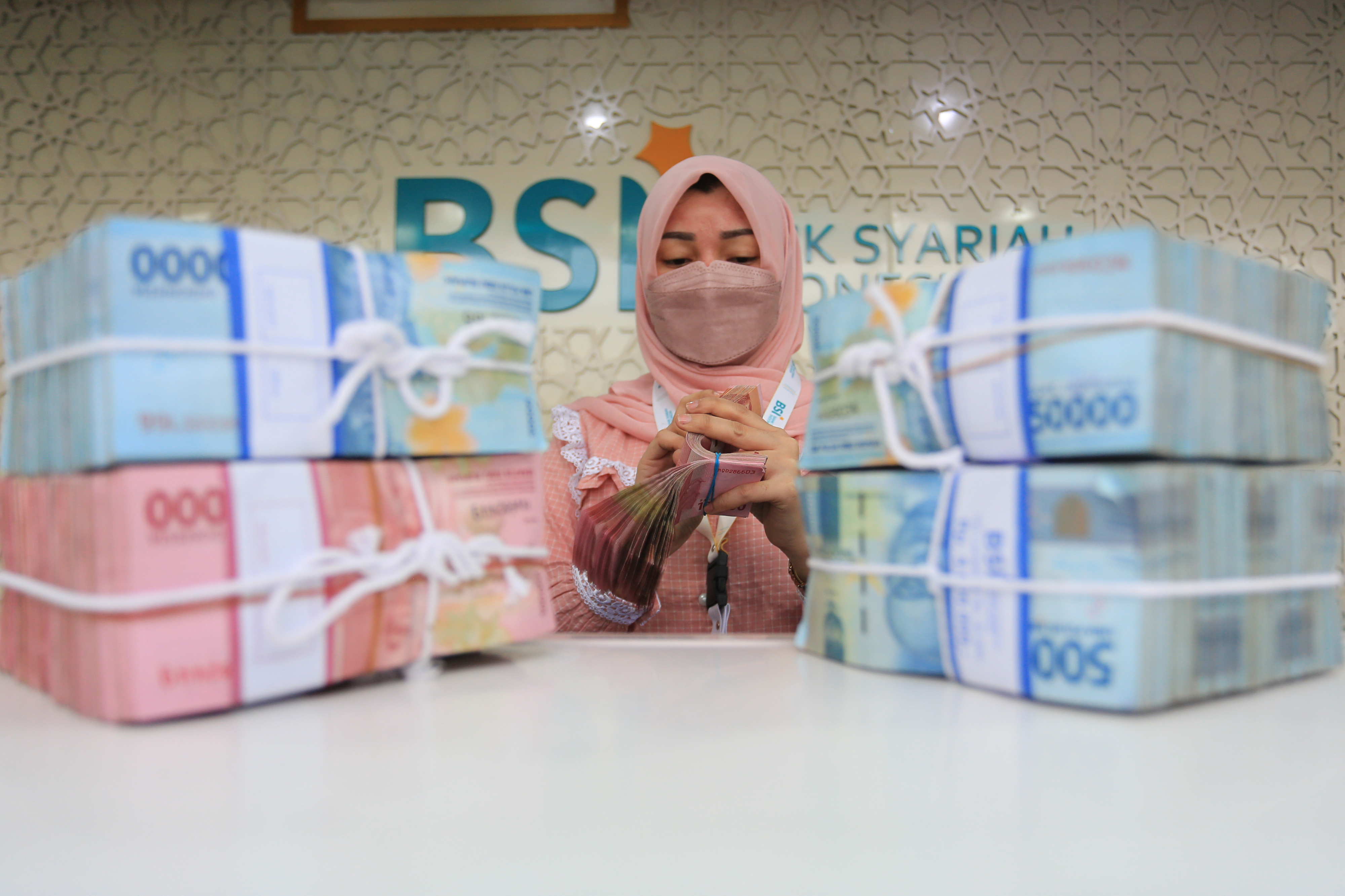 Karyawati Bank Syariah Indonesia (BSI) menghitung uang rupiah di Kantor Cabang Pembantu (KCP) Daud Beureueh, Banda Aceh, Aceh, Jumat (21/1).