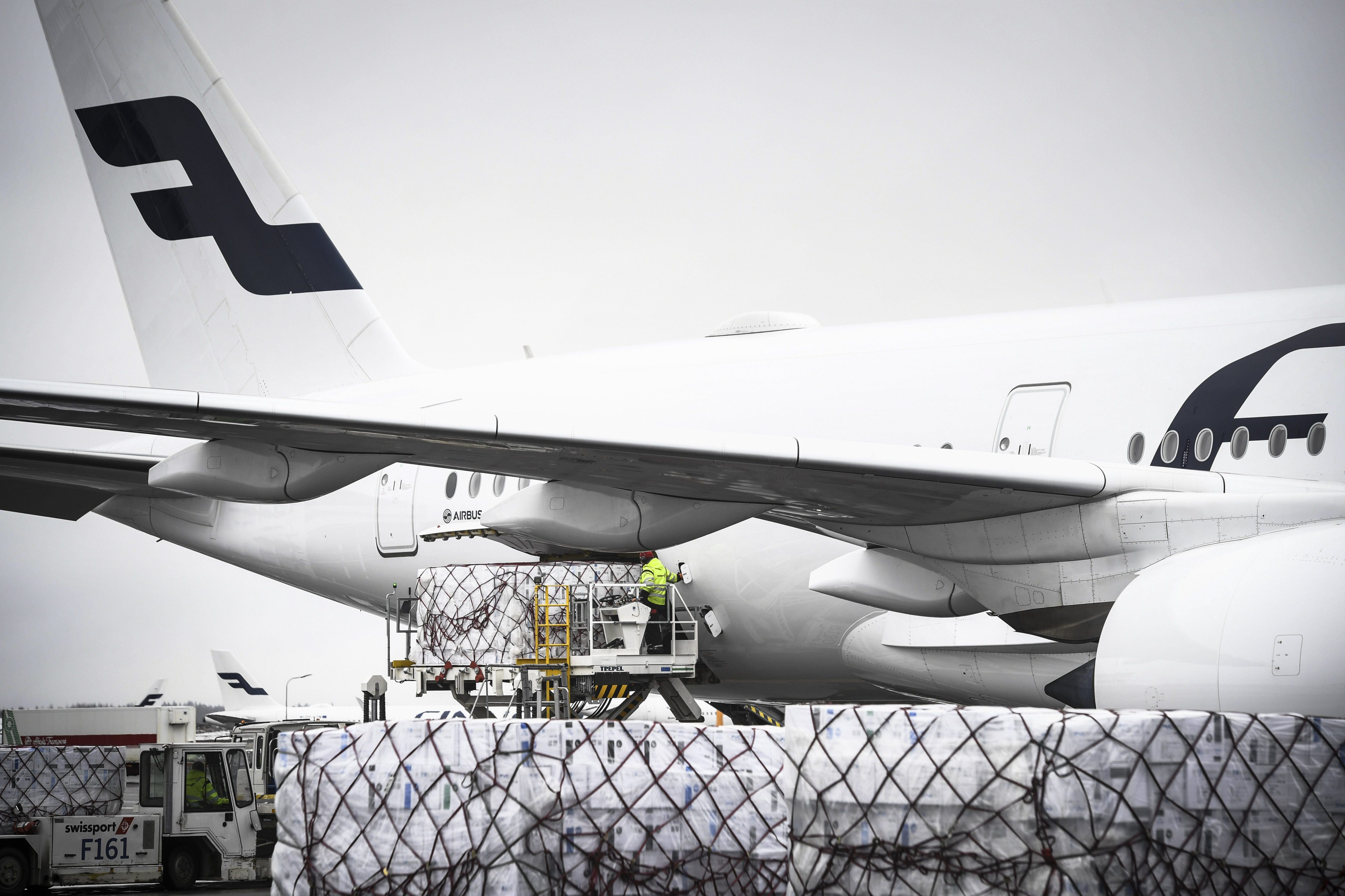 Ilustrasi pekerja membongkar muat kargo dari pesawat di bandara Finlandia.