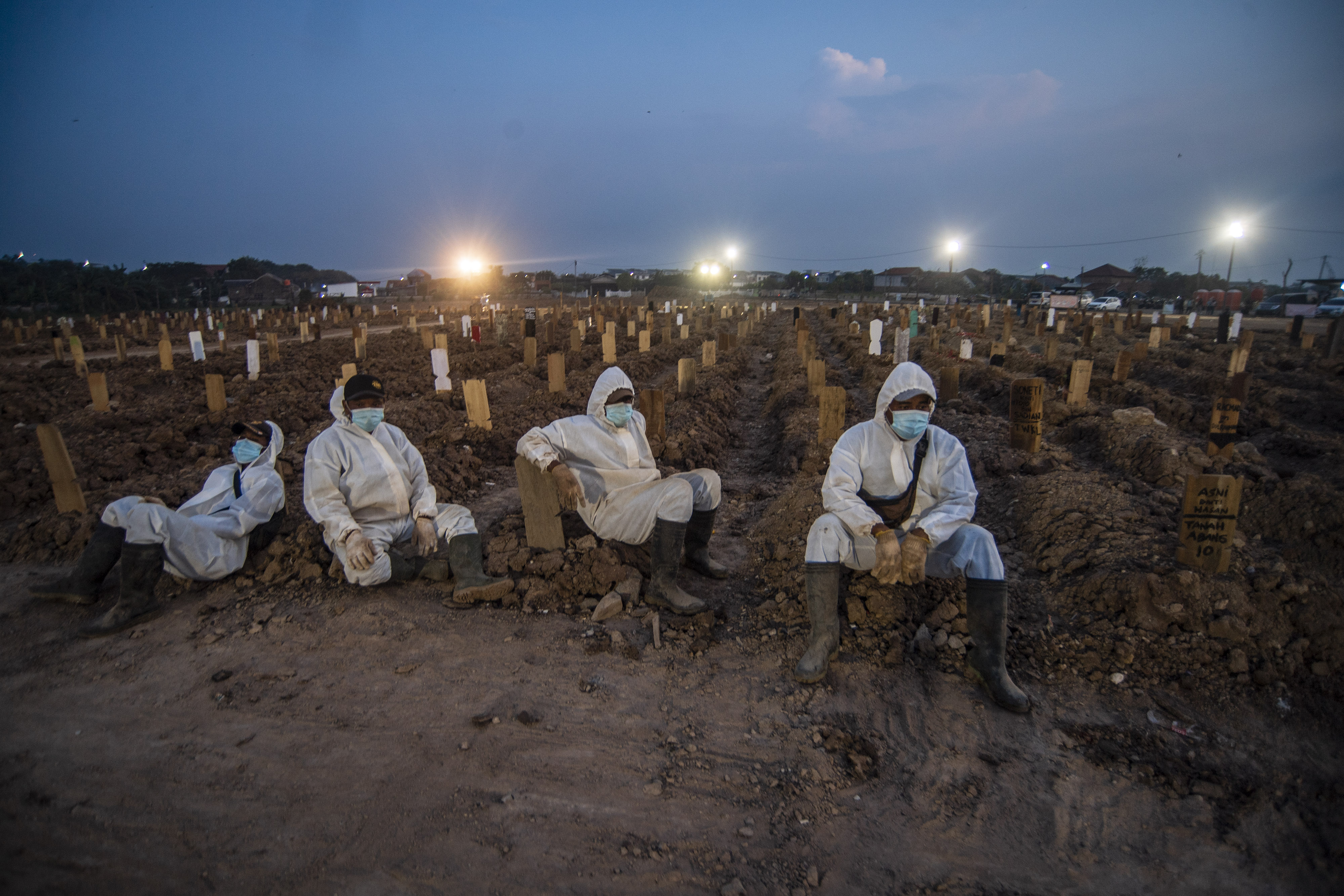 Petugas pemakaman beristirahat usai memakamkan sejumlah jenazah dengan protokol COVID-19 di TPU Rorotan, Cilincing, Jakarta