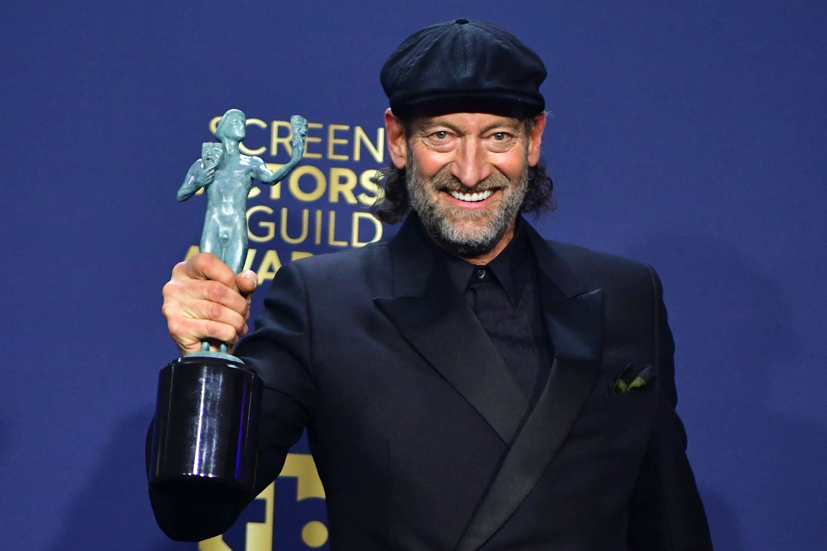 Aktor Troy Kotsur memamerkan trofi SAG Awards yang dimenangkannya.
