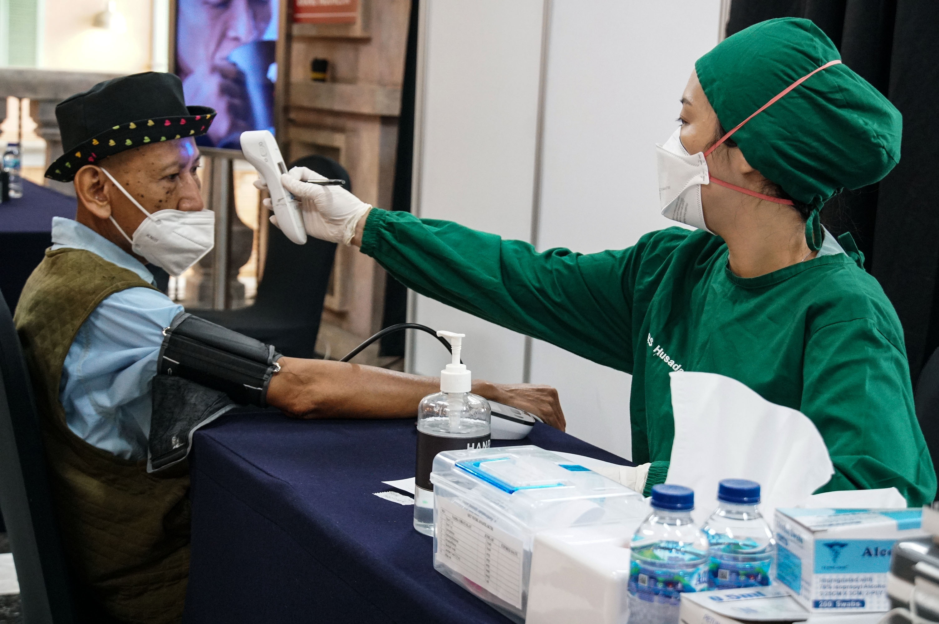 Petugas medis memeriksa kesehatan calon penerima vaksin covid-19 astrazeneca dosis ketiga di Grand Indonesia, Jakarta, Senin (14/2/2022).