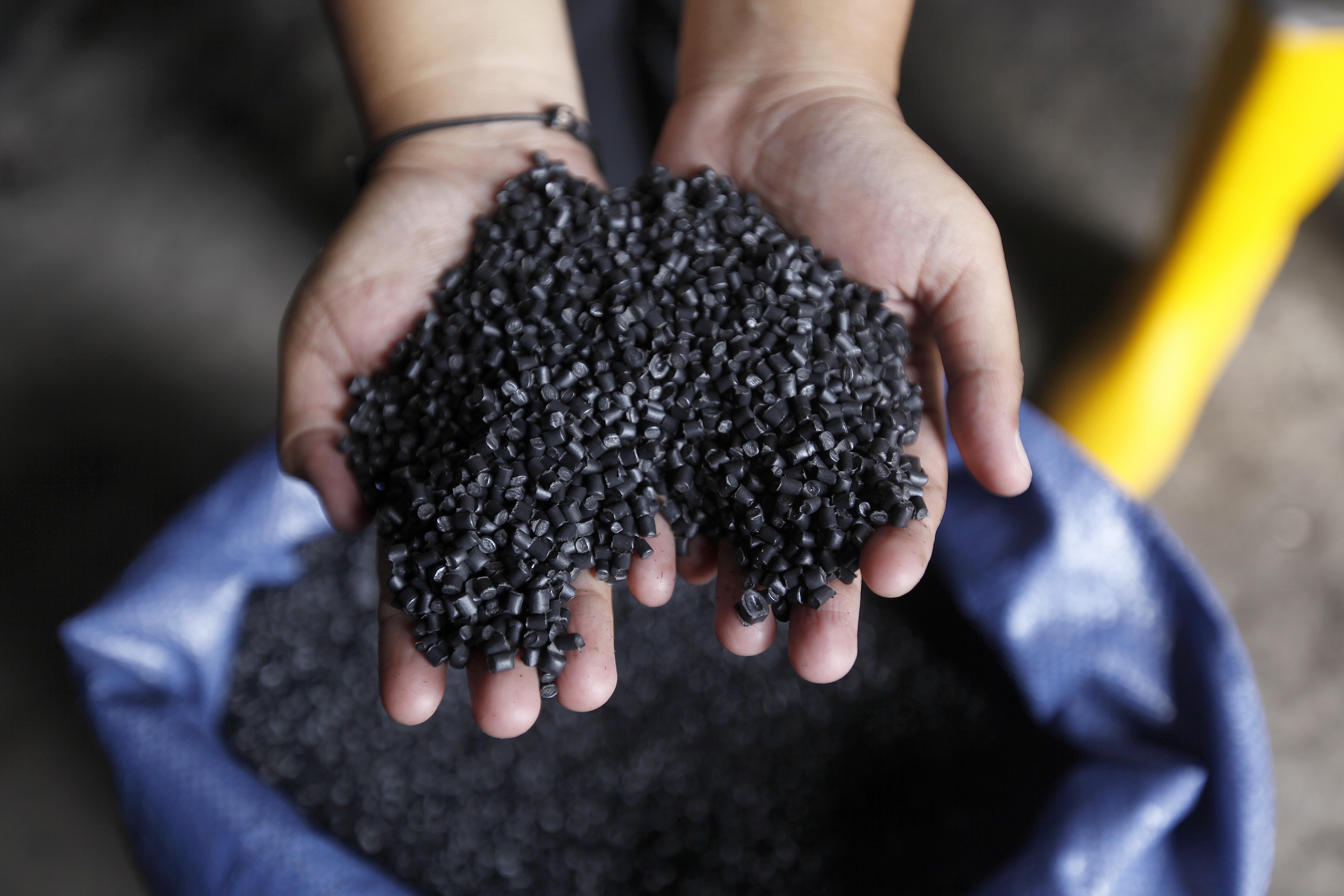 Ilustrasi: Pekerja menunjukkan bijih-bijih plastik hasil olahan sampah yang telah didaur ulang di lokasi pengolahan sampah mandiri