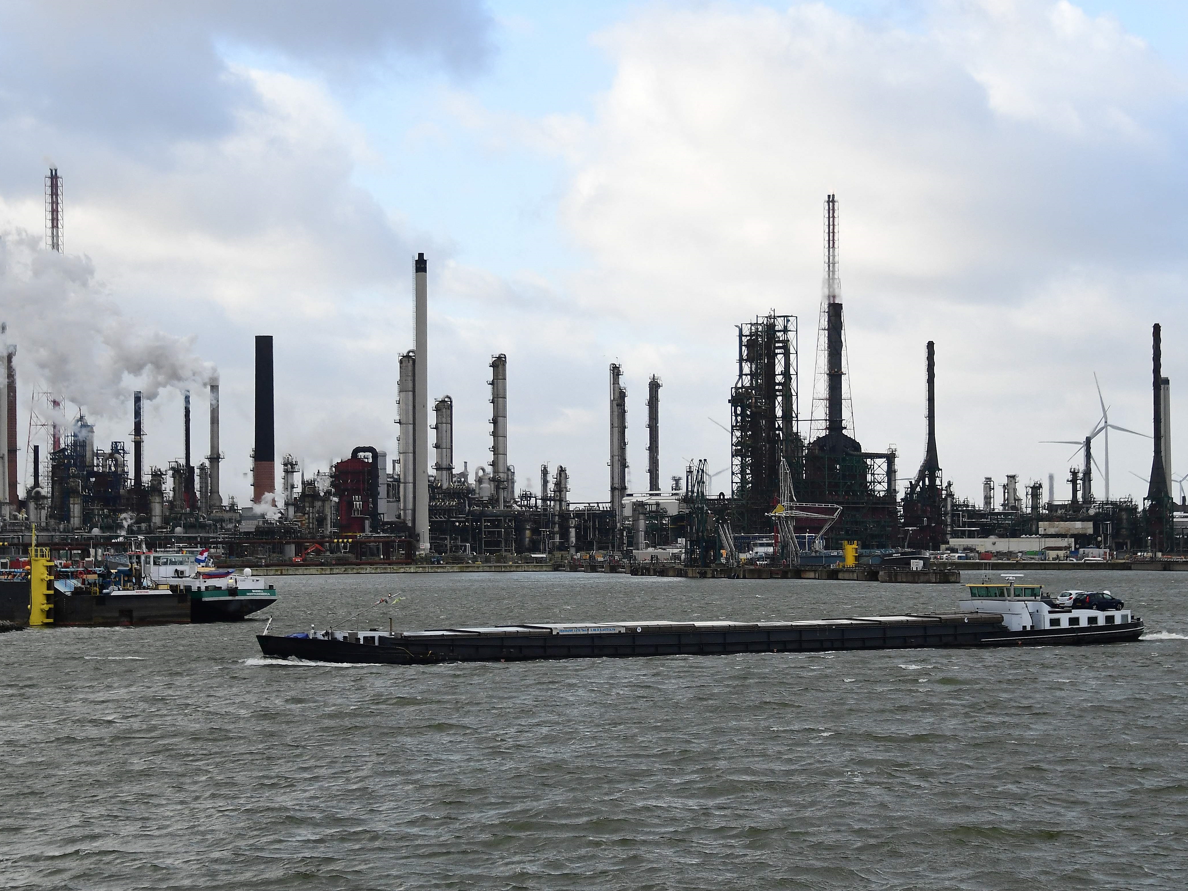 Kapal berlayar melewati industri petrokimia di Pelabuhan Antwerpen.