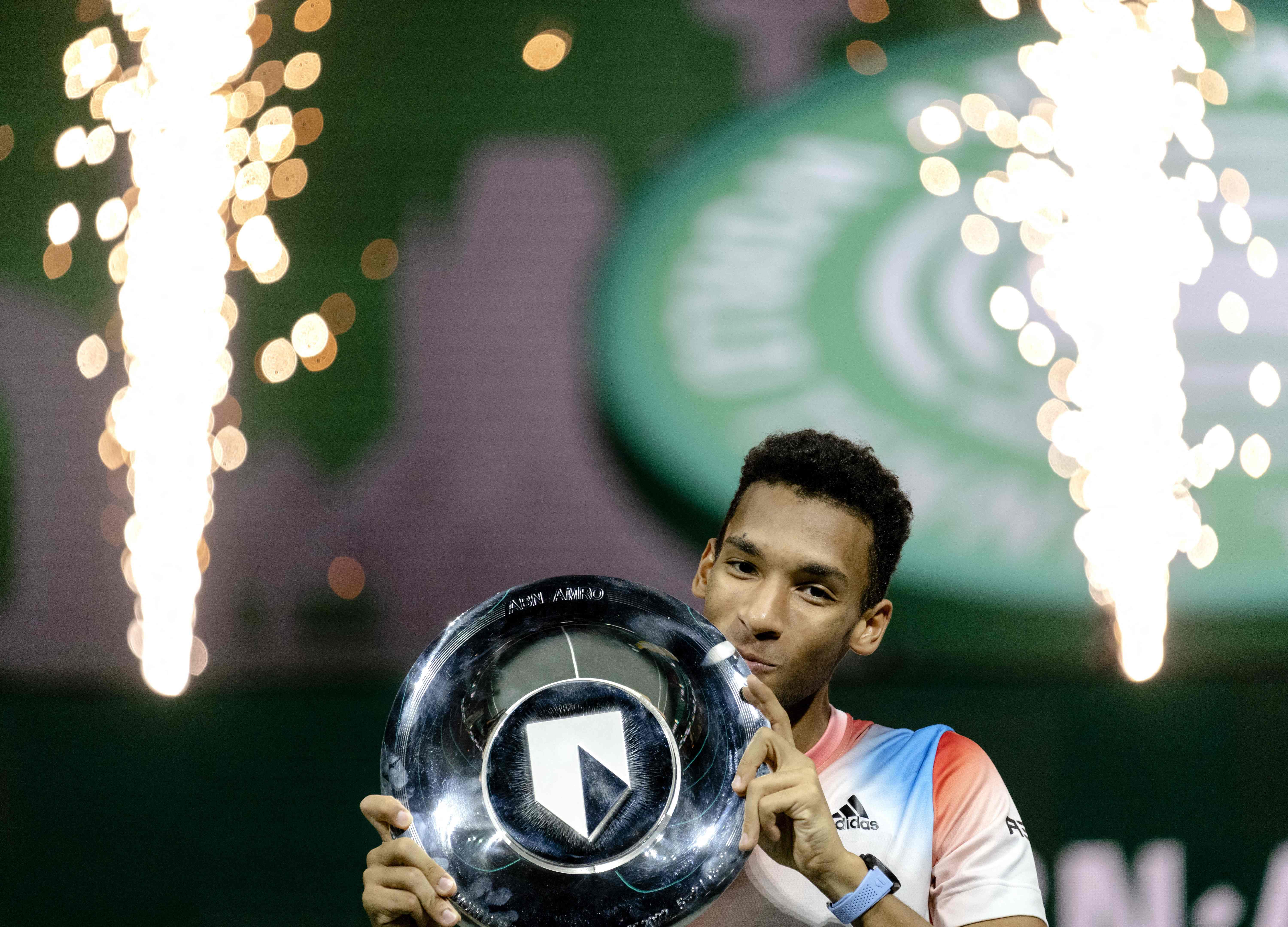 Petenis Kanada Felix Auger-Aliassime berpose dengan trofi Rotterdam Tebruka usai mengalahkan Stefanos Tsitsipas di laga final.