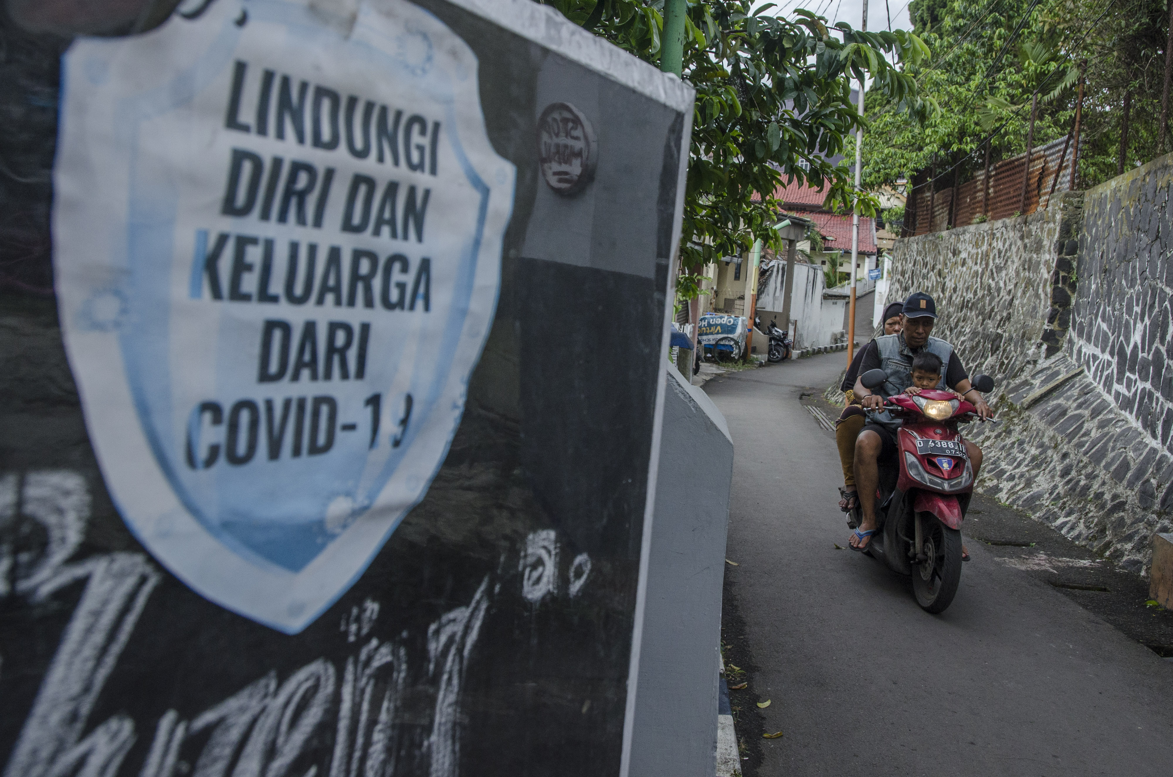 Warga melintasi mural tentang pencegahan penyebaran COVID-19 di Bandung, Jawa Barat.
