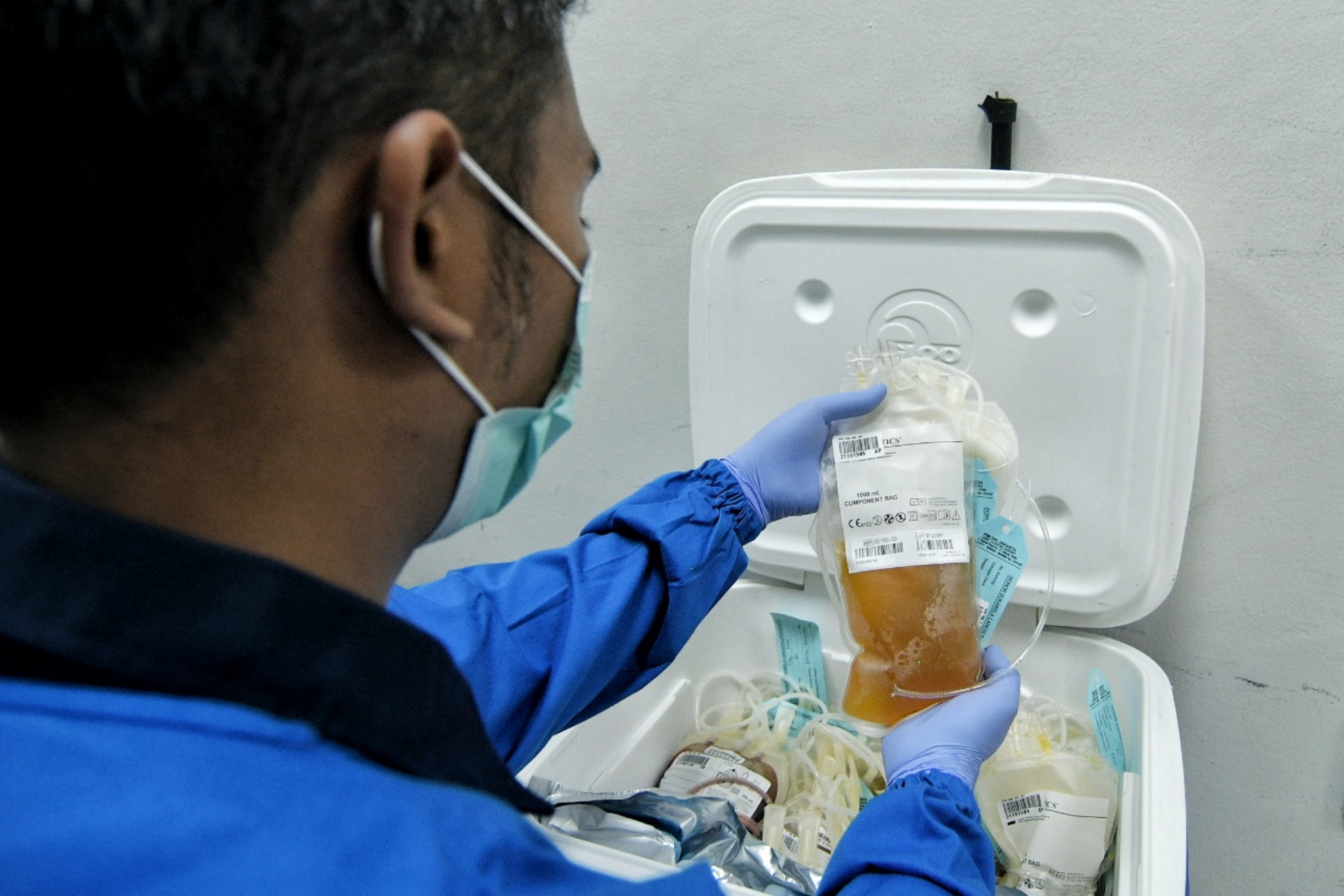 Tenaga kesehatan memegang kantong hasil donor plasma konvalesen