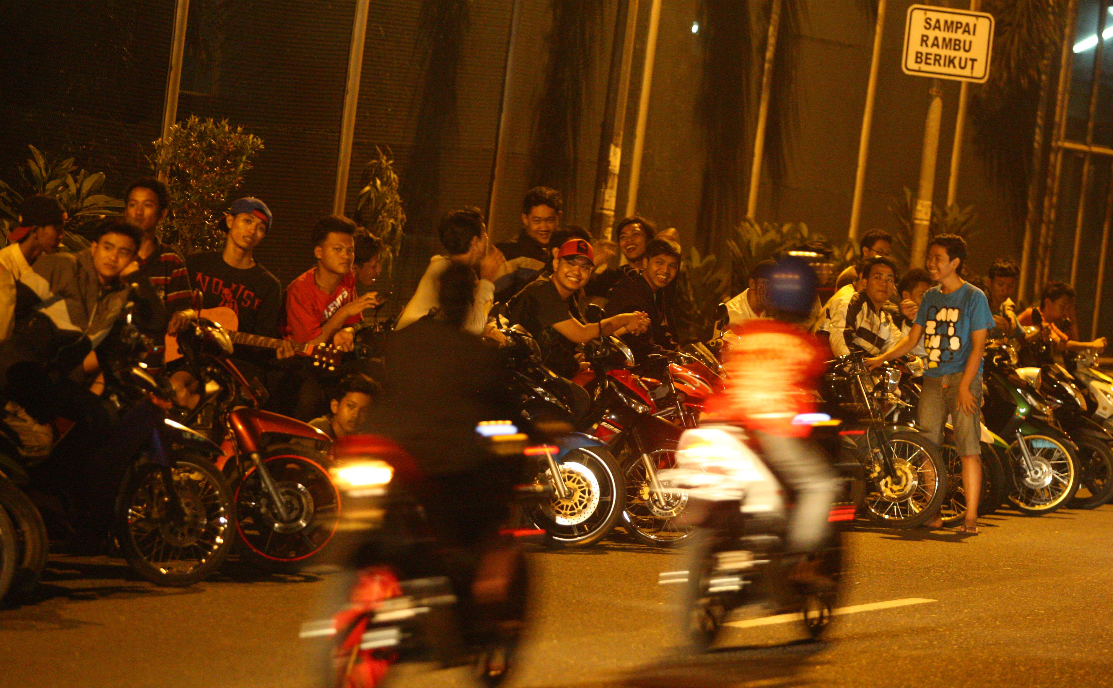Sejumlah pemuda dari bermacam geng motor berkumpul ditepi jalan untuk menyaksikan balap liar tiap akhir pekan dan hari libur