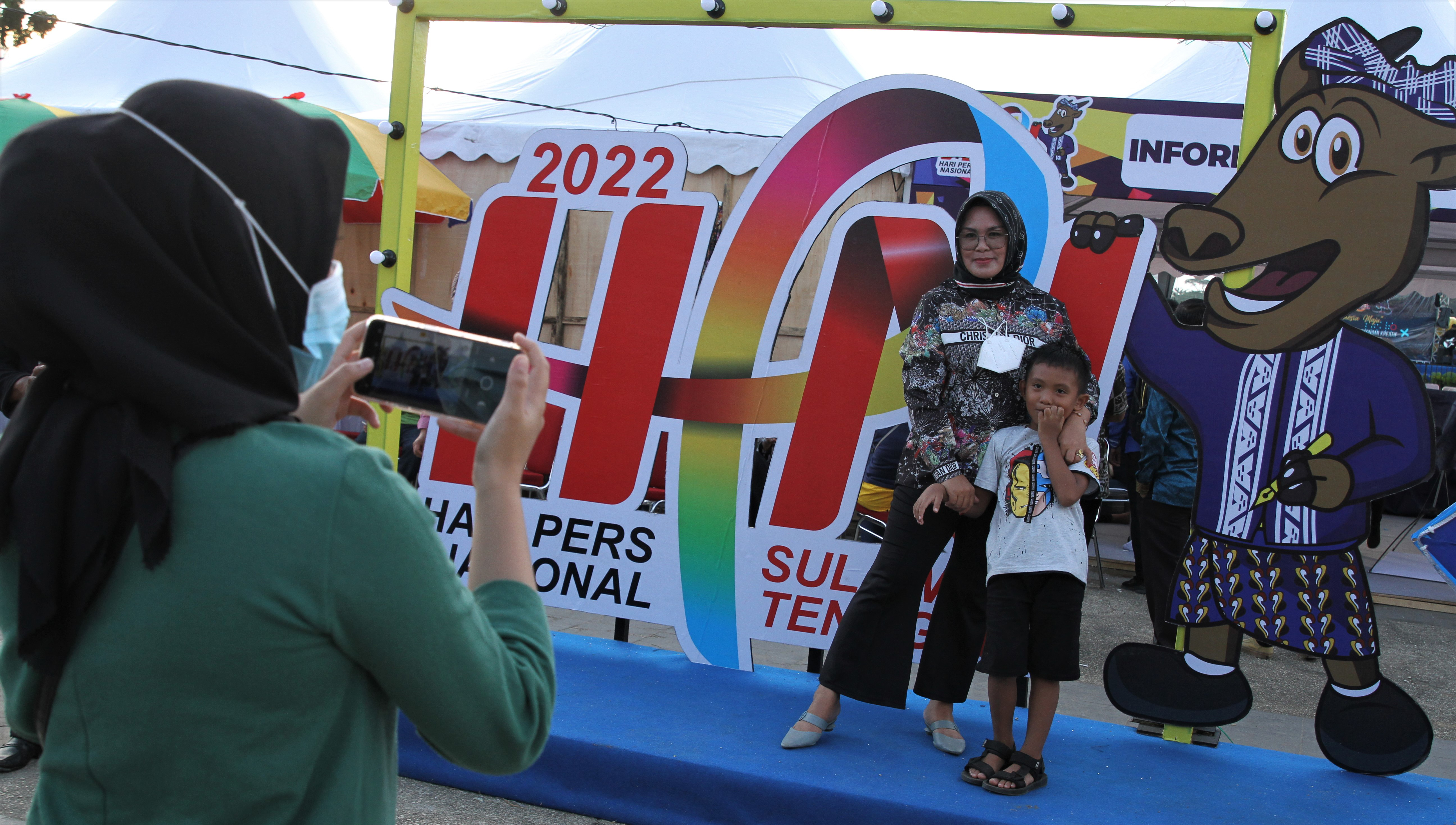 Pengunjung berfoto di maskot dan logo peringatan Hari Pers Nasional (HPN) 2022 di areal MTQ Square, Kendari, Sultra, Minggu (6/2).