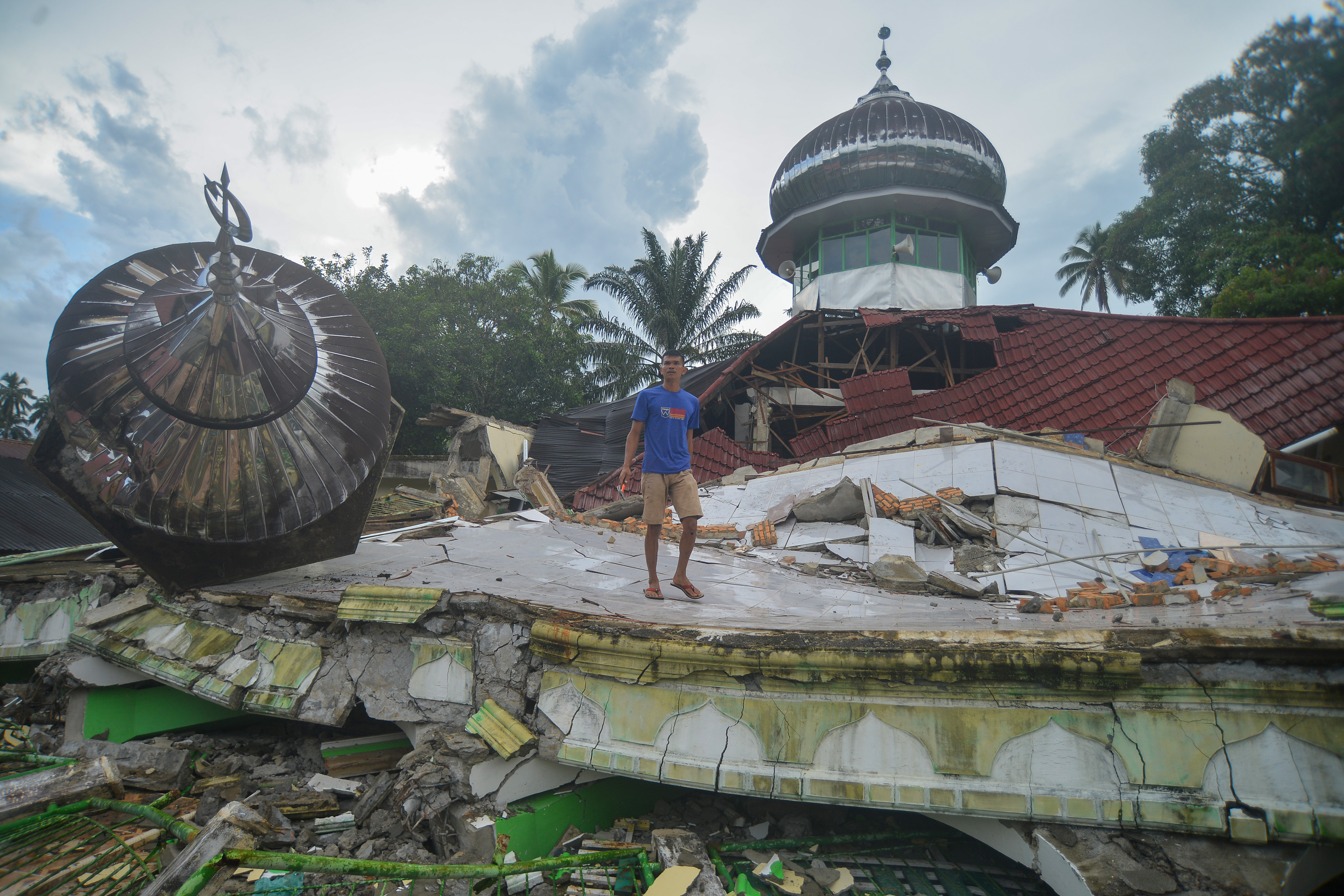 Warga mencari warga lain yang diduga terjebak di reruntuhan masjid akibat gempa di Nagari Kajai, Kabupaten Pasaman Barat, Sumatera Barat