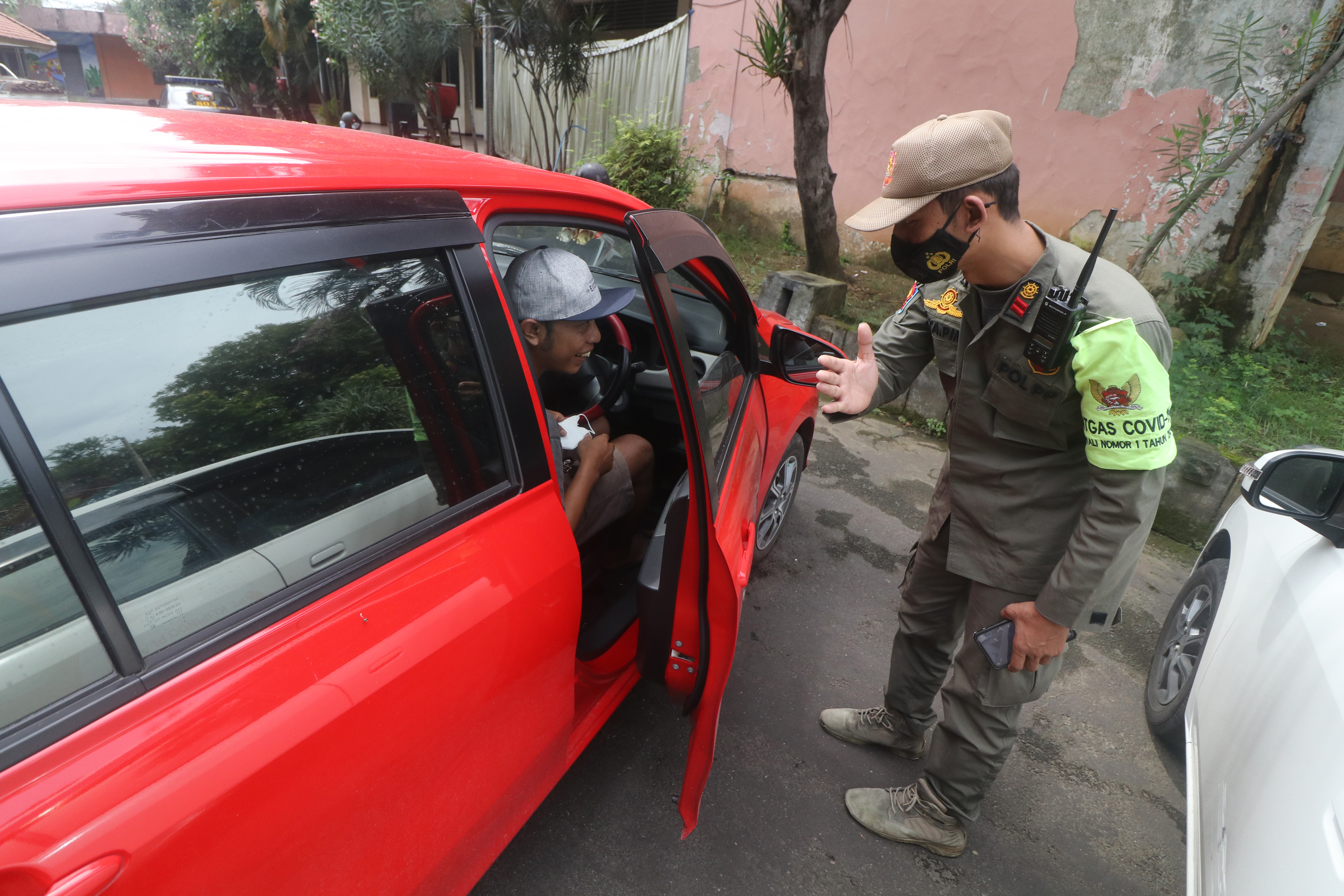 Petugas menghentikan pengendara mobil tanpa masker saat razia penegakan prokes covid-19 di Kota Kediri, Jawa Timur, Jumat (11/2/2022).