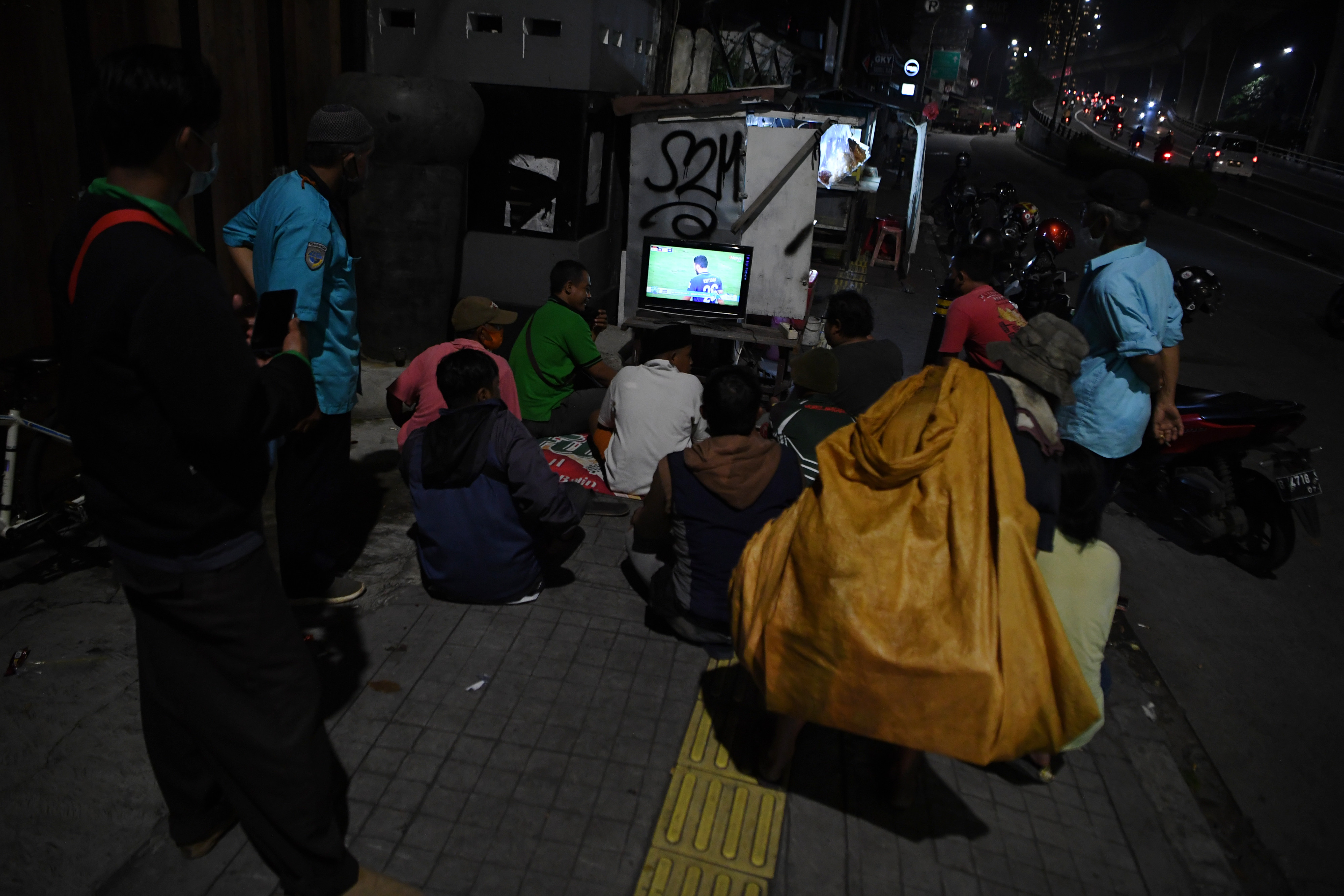 Sejumlah warga menyaksikan televisi di daerah Kebayoran Lama, Jakarta.