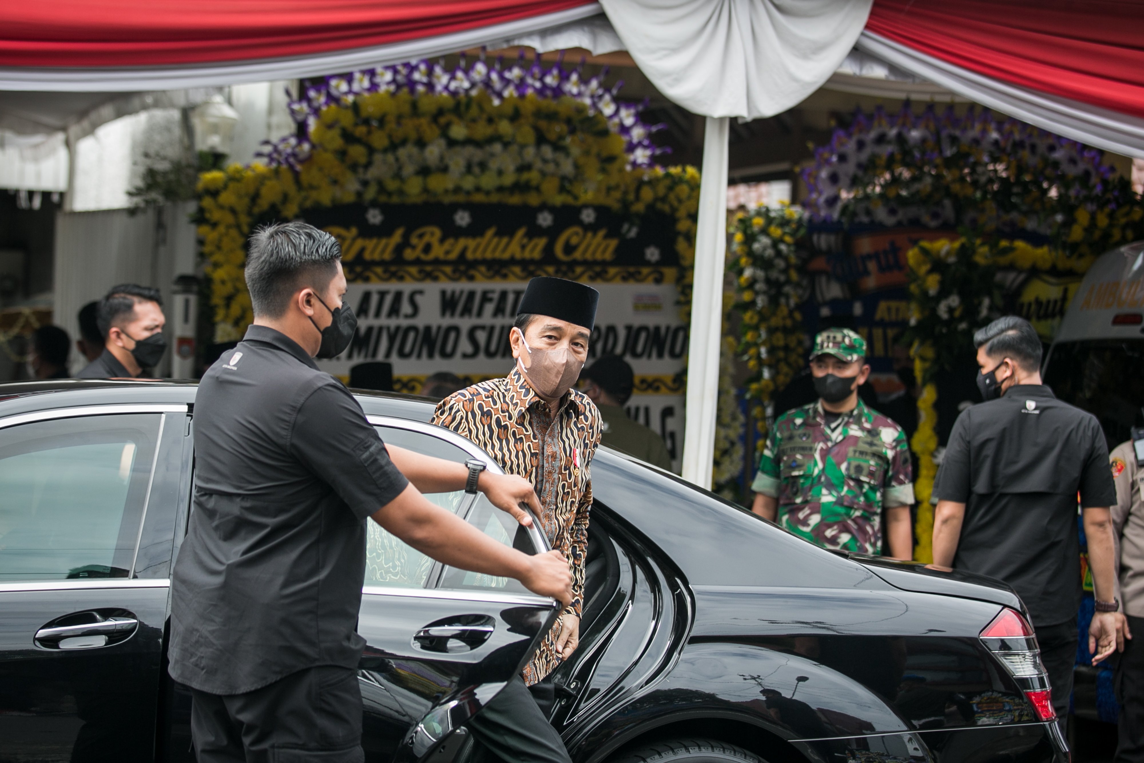 Presiden Jokowi turun dari mobil saat tiba di rumah duka kediaman almarhum Miyono Suryosardjono di Solo.