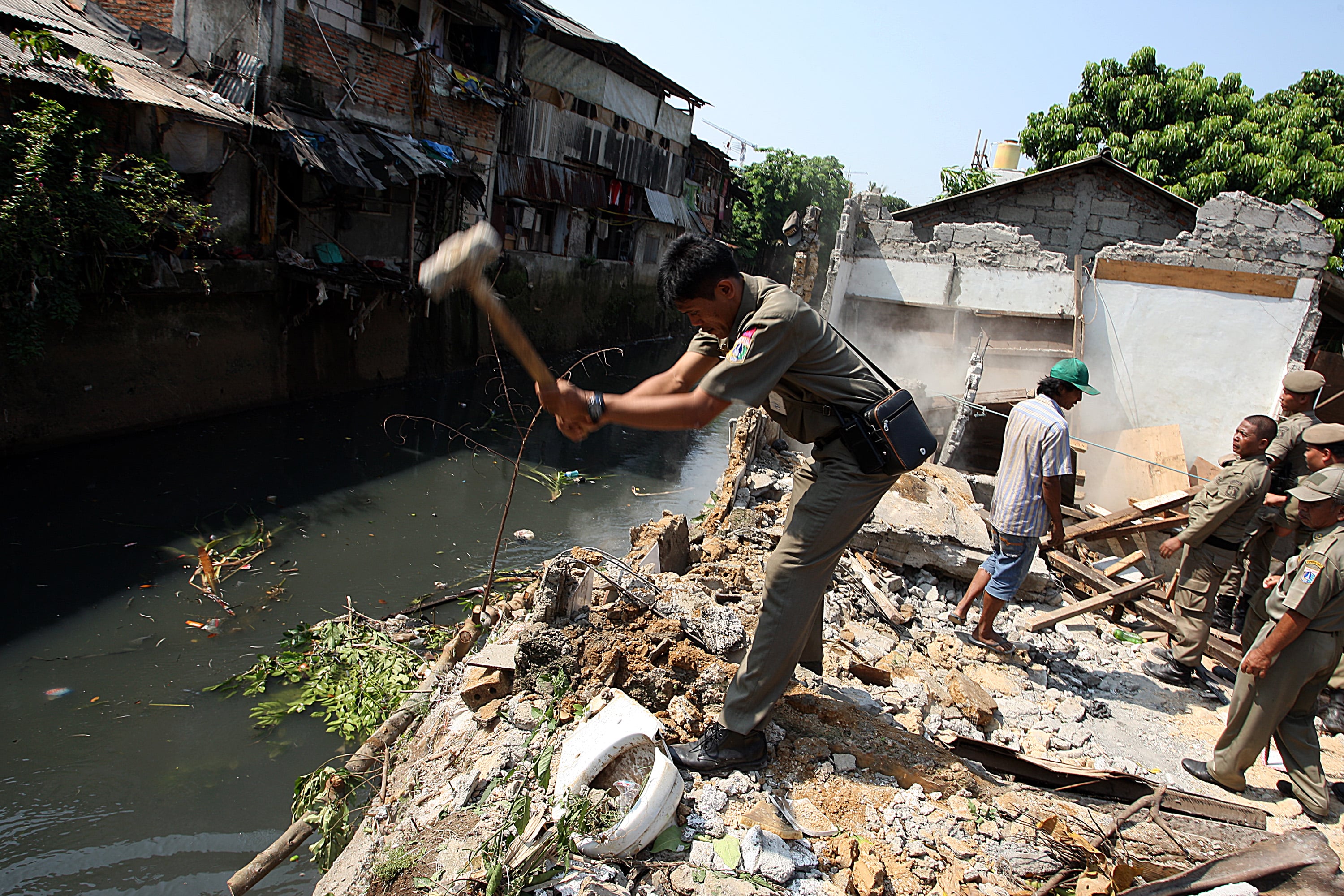 Petugas Satpol PP Jakarta Selatan membongkar bangunan liar di sepanjang bantaran Kali Mampang, Jakarta Selatan.