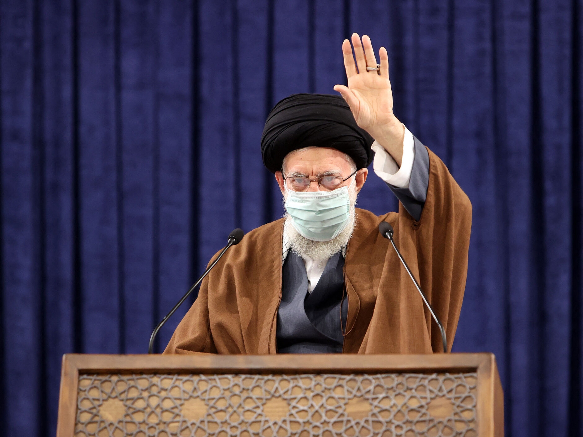 Ayatollha Ali Khamenei melambaikan tangan selama konferensi video di Teheran pada 17 Februari 2022.