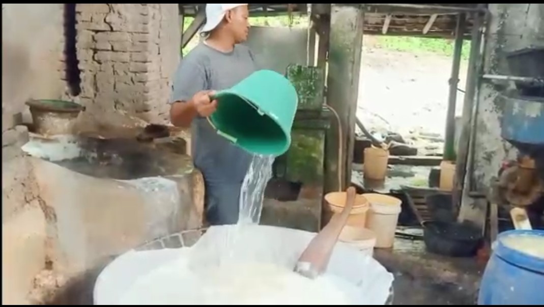 Perajin tahu sedang memroses pembuatan tahu.