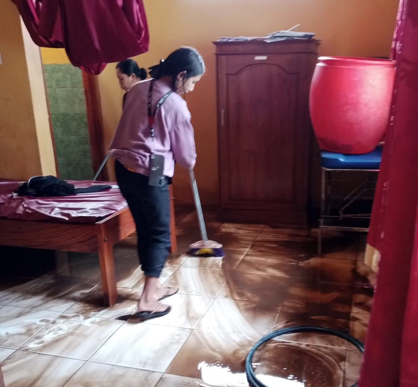 Petugas medis Puskesmas Rekas sedang membersihkan seluruh ruangan akibat banjir berlumpur yang menggenangi isi ruangan itu.
