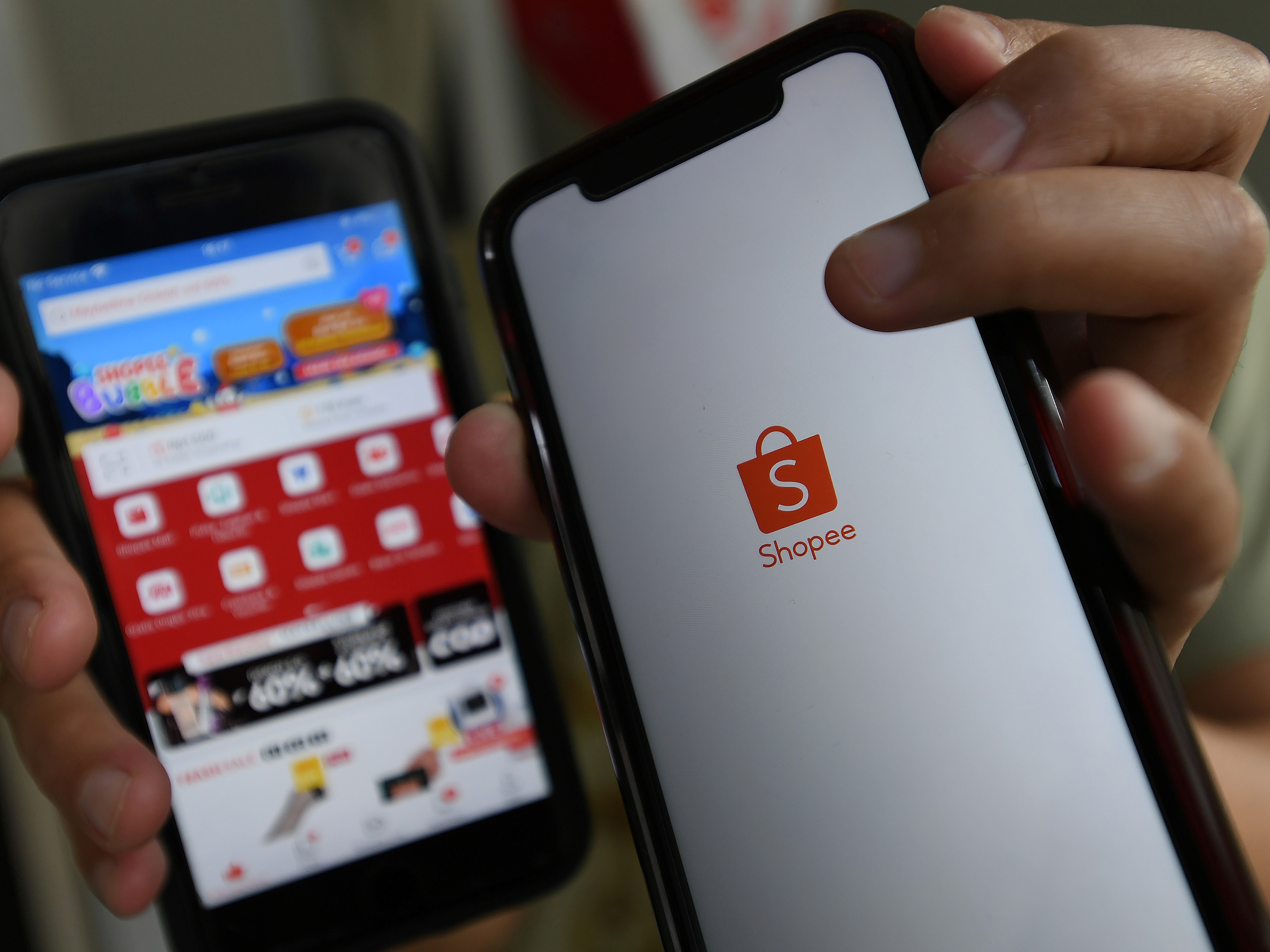 Konsumen menunjukkan aplikasi belanja online Shopee melalui gawai di Jakarta.