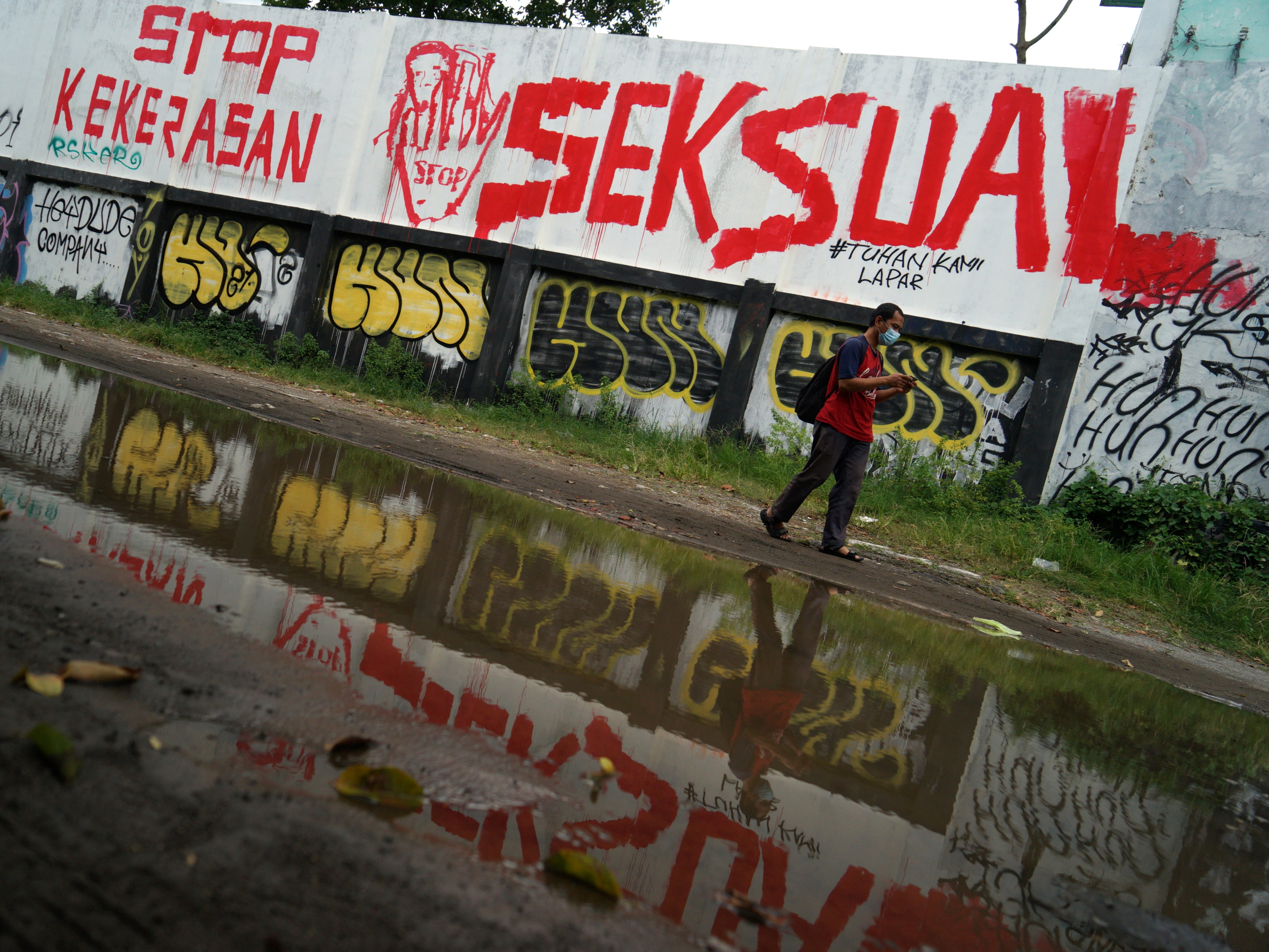 Warga melintas di dekat mural setop kekerasan seksual di Lapangan Kridosono, Yogyakarta, Senin (10/1/2022).