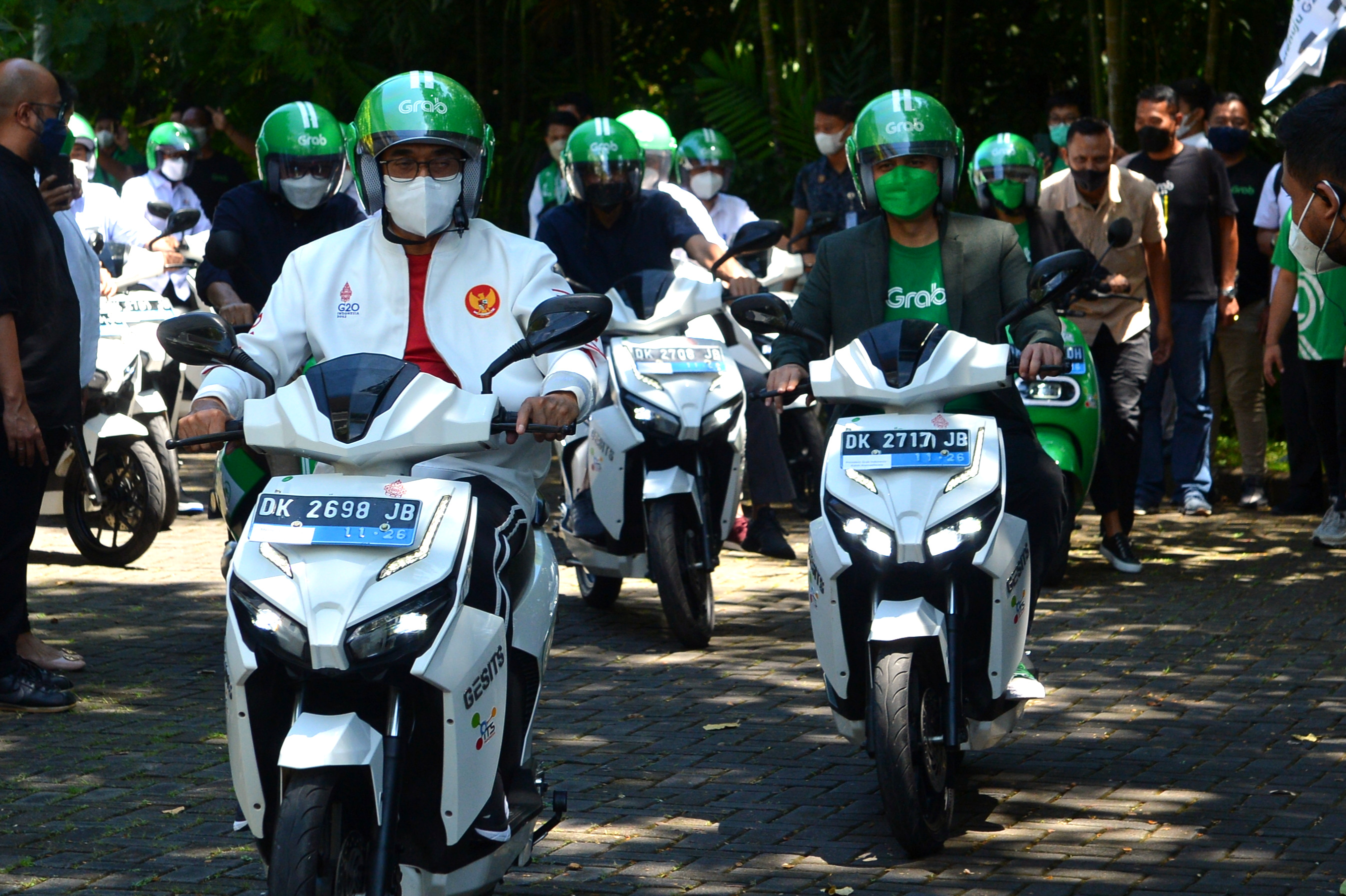 Menteri Perhubungan Budi Karya Sumadi (kiri) mengendarai sepeda motor listrik.