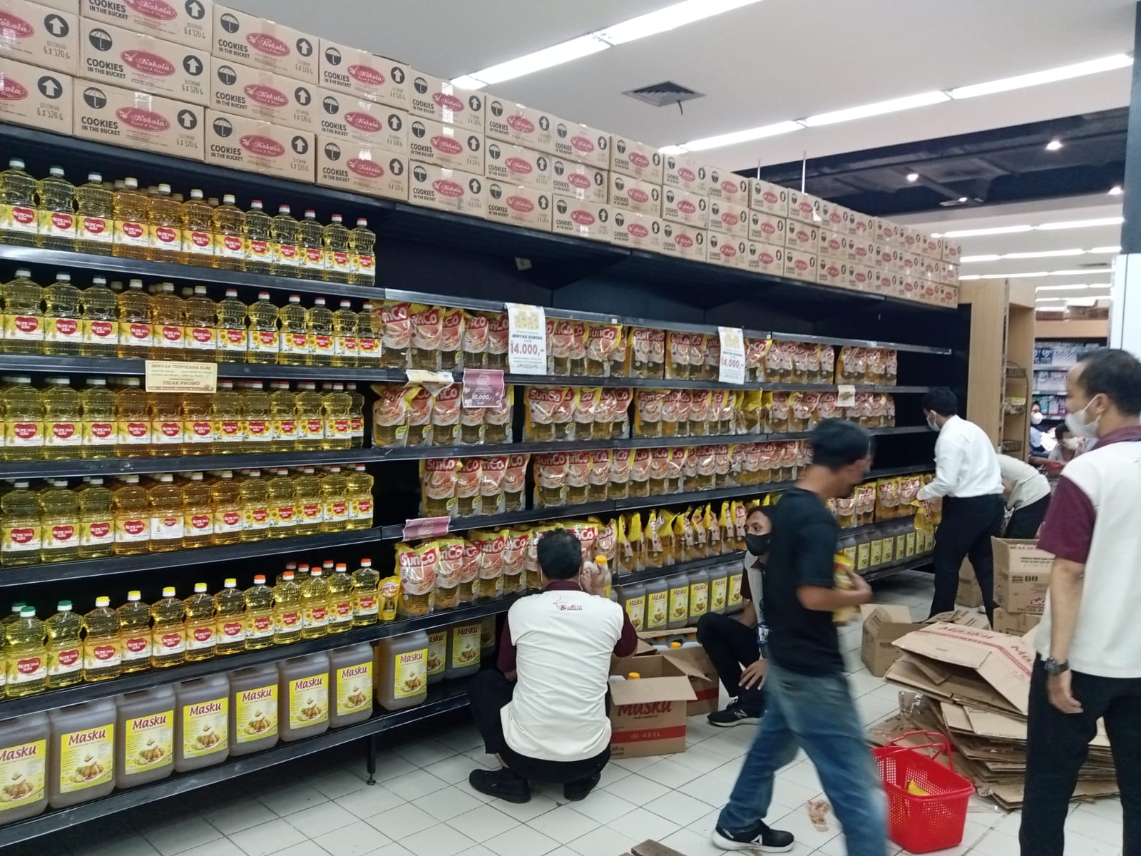 Pekerja di sebuah supermarket menata minyak goreng