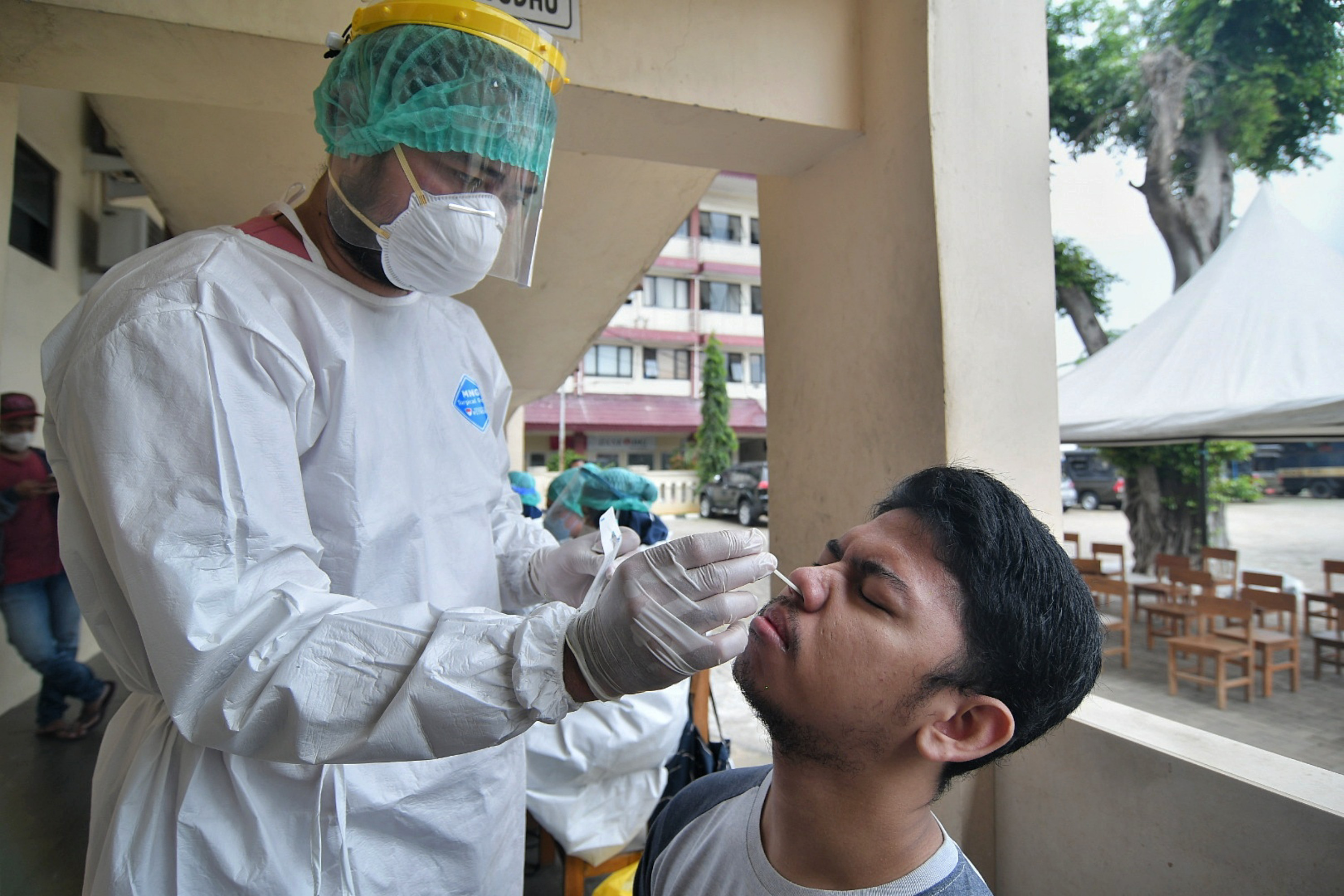 Tenaga kesehatan melakukan tes PCR pada warga