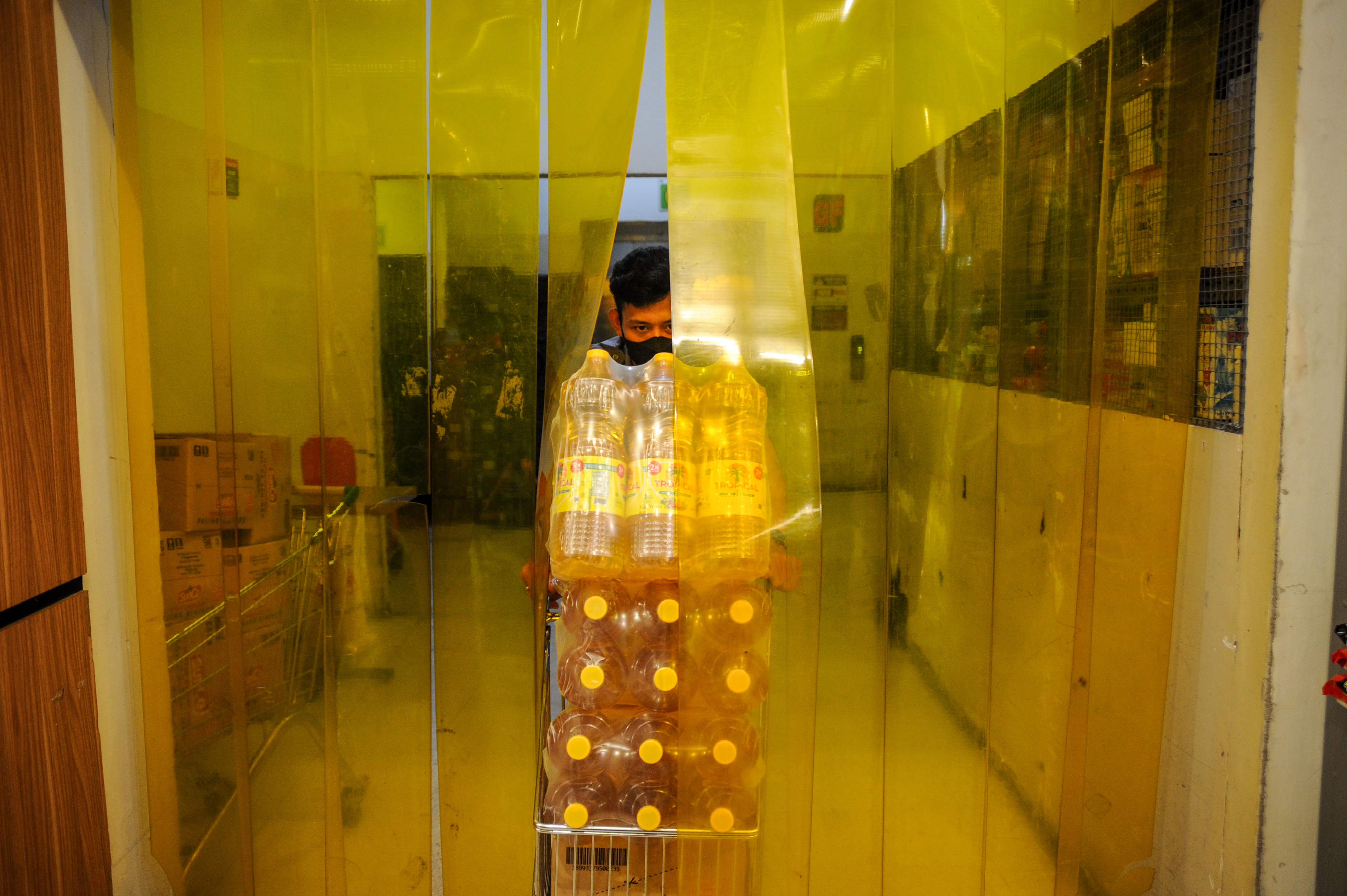 Pekerja membawa minyak goreng di sebuah gudang salah satu supermarket di Bandung.