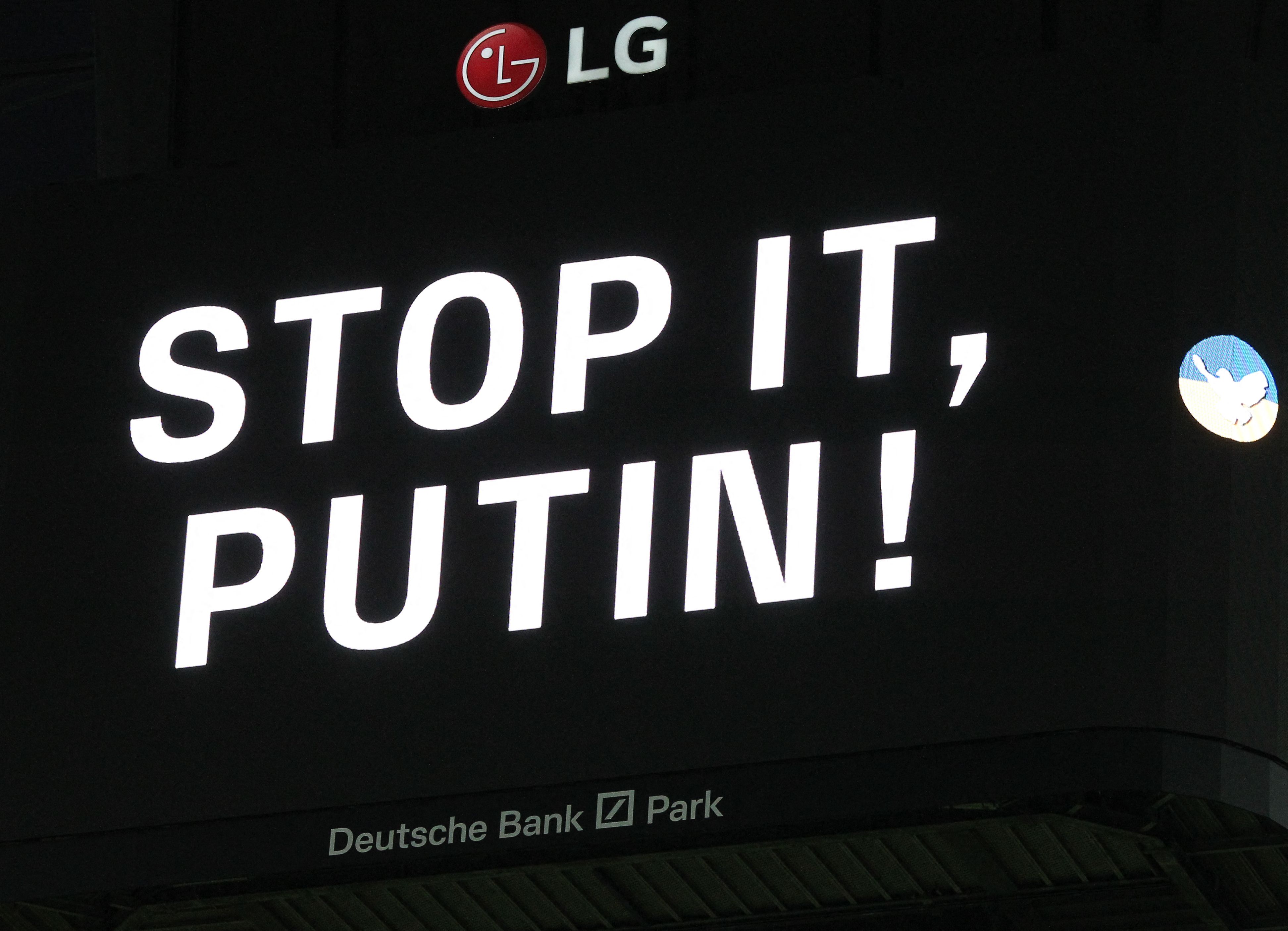 Layar elektronik raksasa menunjukkan seruan kepada Presiden Rusia Vladimir Putin.