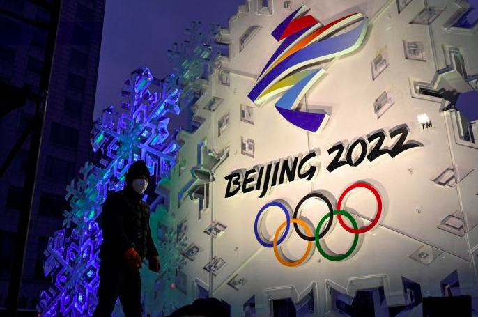 Seorang pekerja sedang menata instalasi yang menampilkan logo Olimpiade Beijing 2022 di Beijing, Tiongkok, Jumat (21/1/2022).