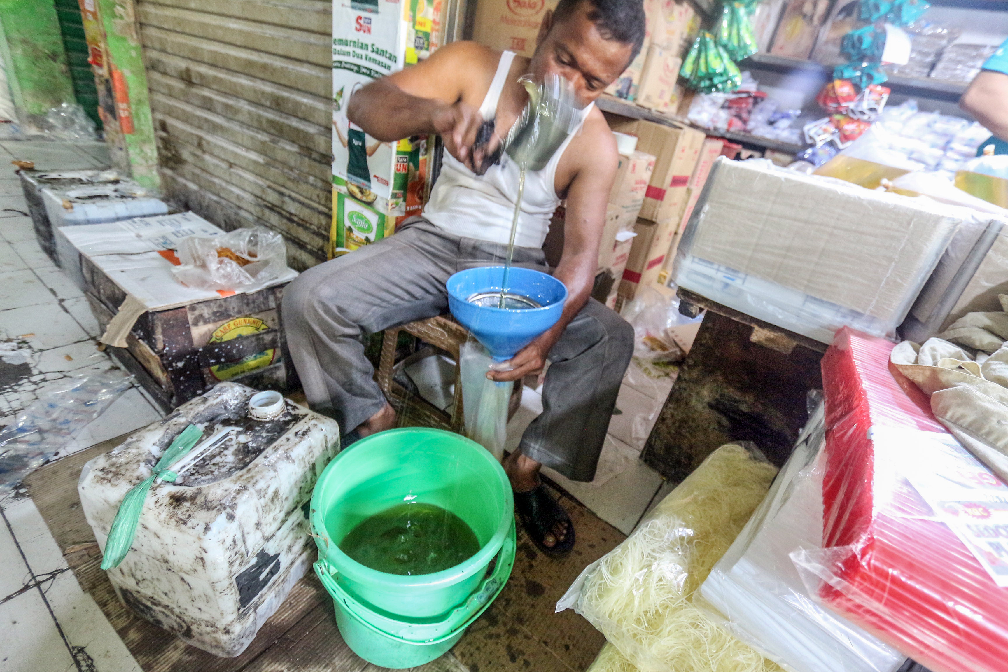 Pedagang mengemas minyak goreng curah yang dijual di Pasar Cibinong, Kabupaten Bogor.