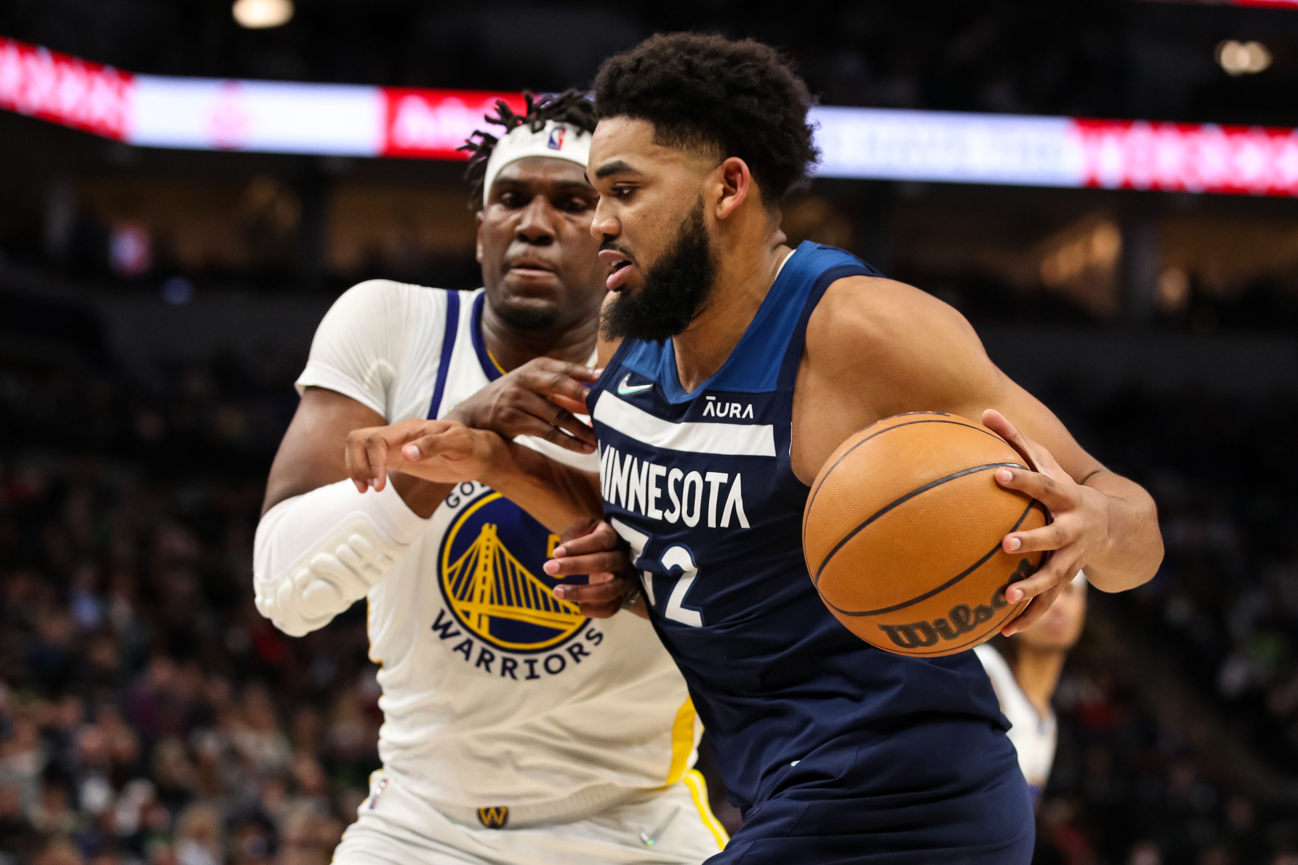 Bintang Minnesota Timberwolves Karl-Anthony Towns berusaha melewati pemain Golden State Warriors di laga NBA.