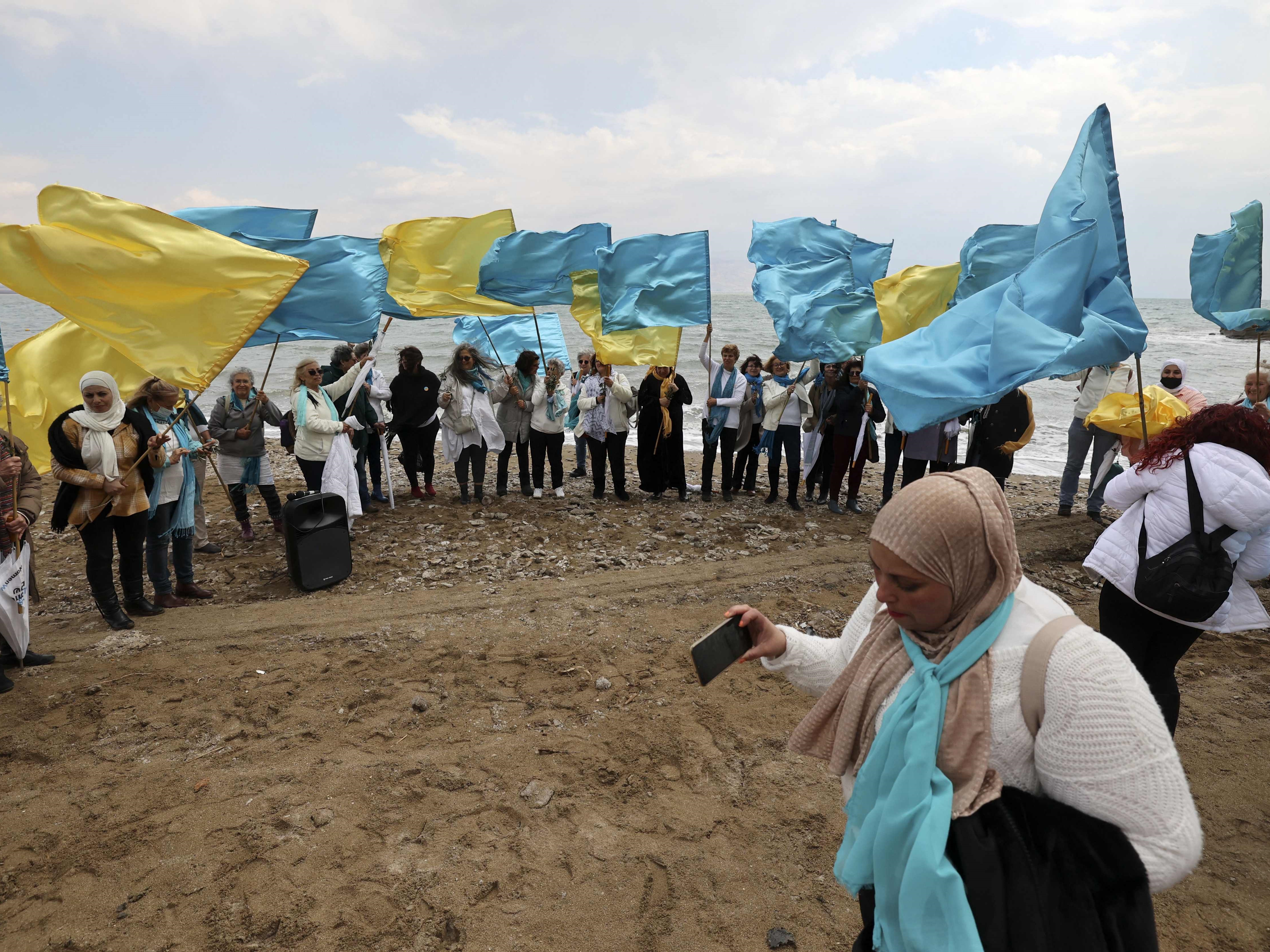 Wanita Israel dan Palestina, anggota dari dua gerakan perdamaian lokal, mengibarkan bendera mereka.