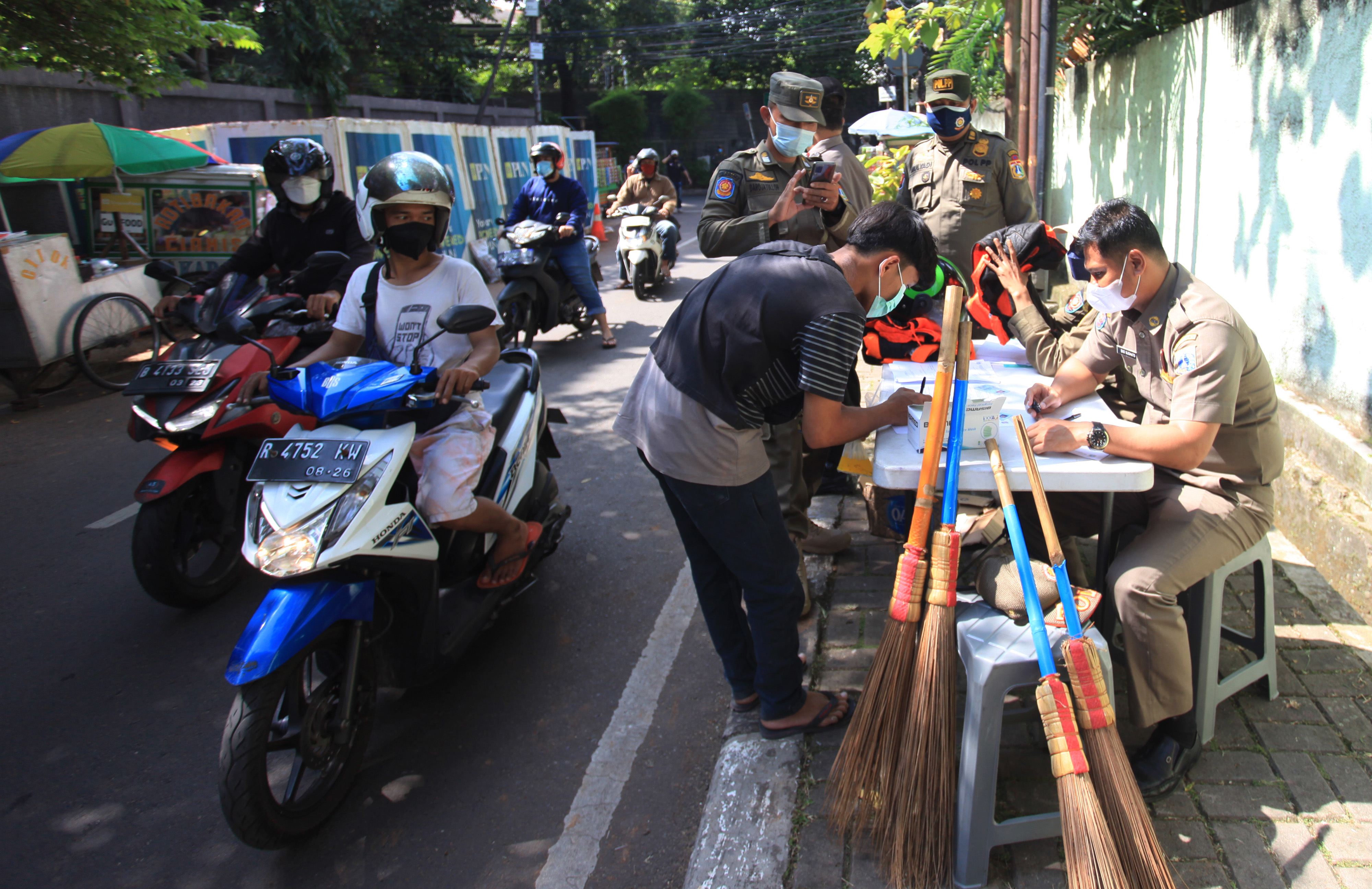 Petugas mencatat data warga yang tidak memakai masker saat razia protokol kesehatan di kawasan Cilandak, Jakarta, Kamis (3/2/2022), 