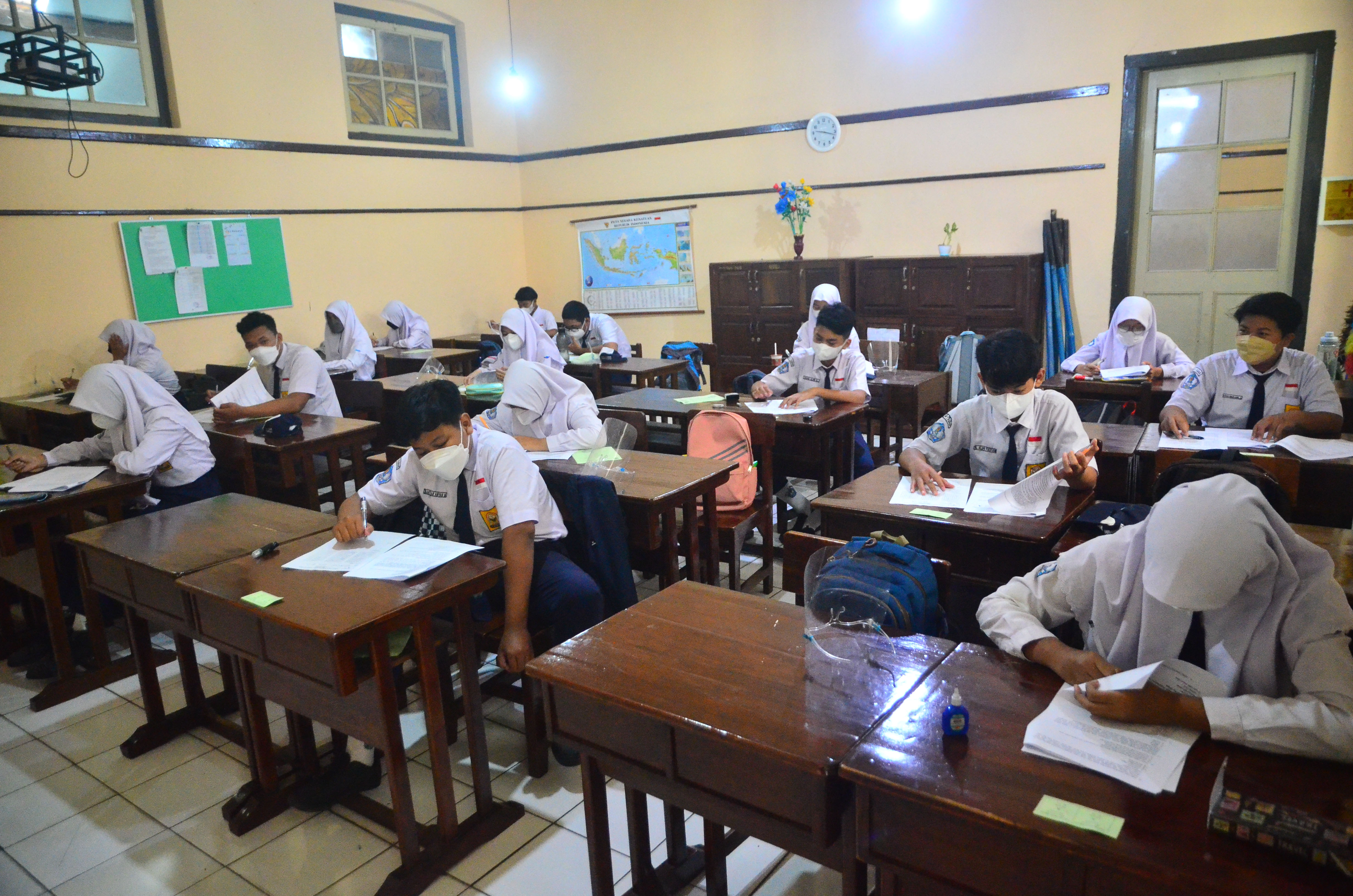 Siswa mengerjakan soal ujian sekolah di SMPN 1 Kudus, Kudus, Jawa Tengah.