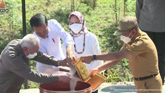 Presiden Jokowi menuangkan tanah ke dalam sebuah gentong yang diletakkan tepat di titik nol IKN.