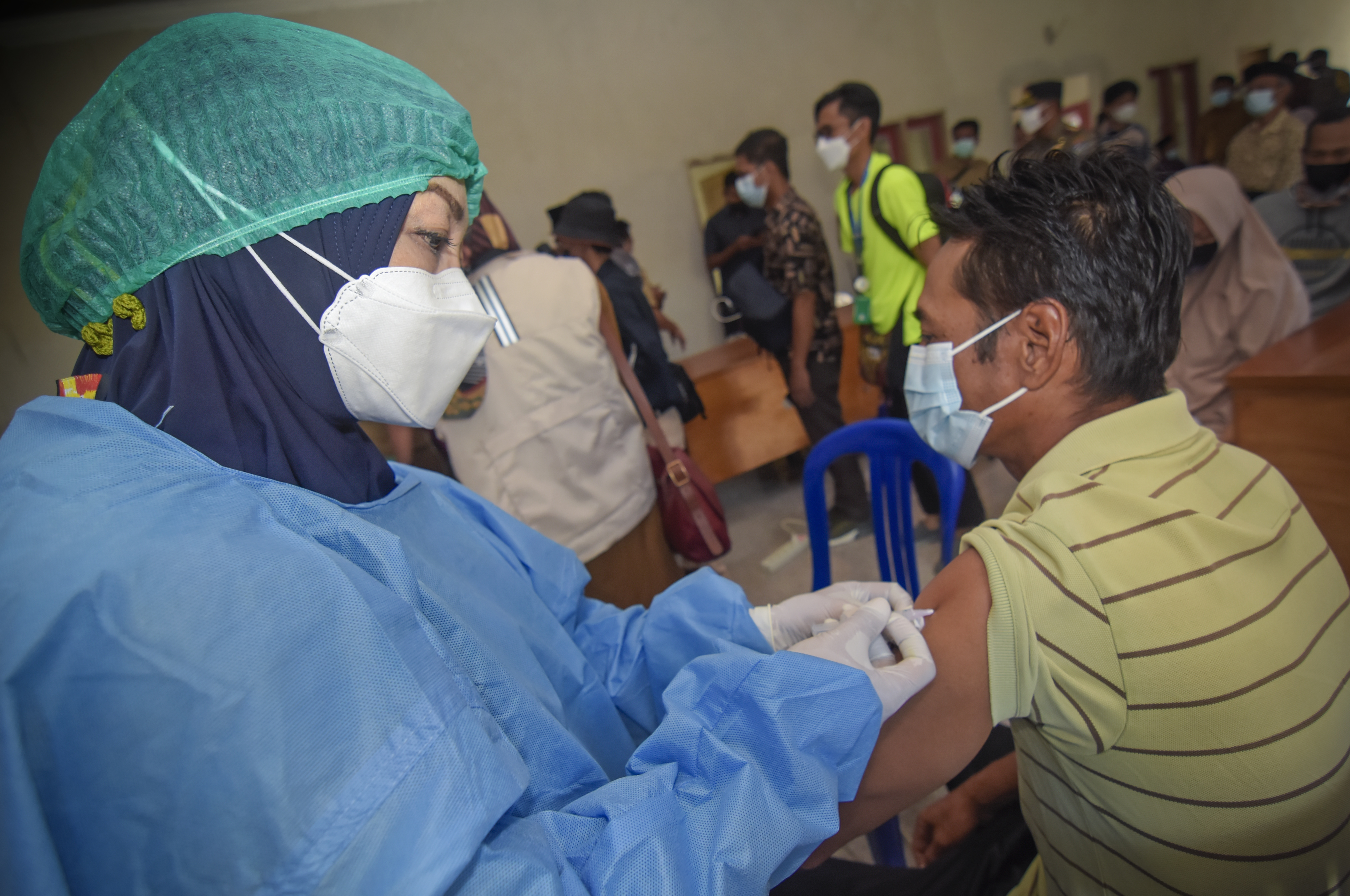 Petugas menyuntikkan vaksin COVID-19 kepada warga di Kantor Desa Tanak Awu, Kecamatan Pujut, Praya, Lombok Tengah, NTB