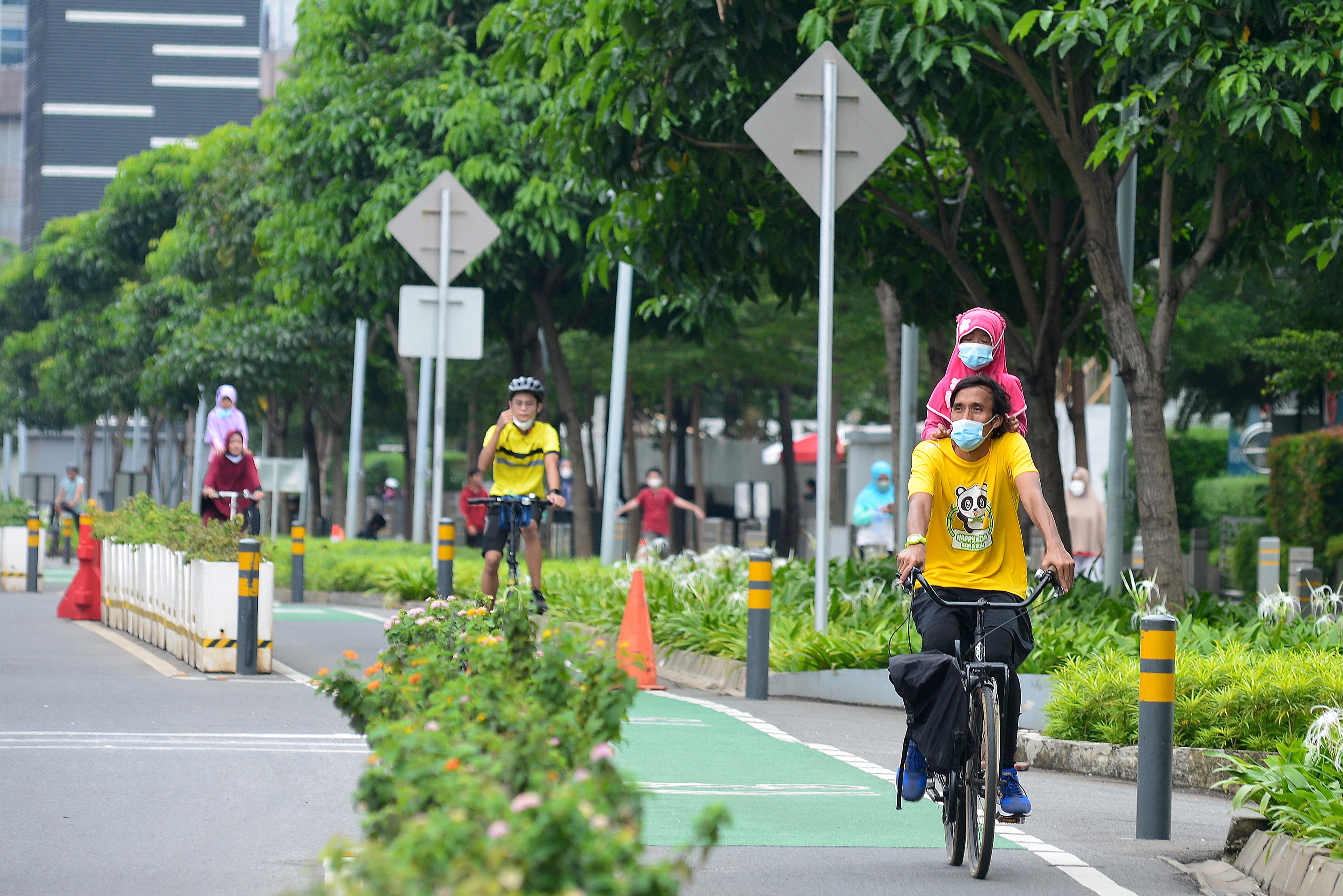 Warga bersepeda di jalur sepeda di kawasan Sudirman, Jakarta, Minggu (13/3/2022).