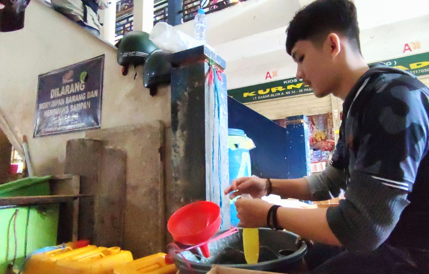 Pedagang sembako di Pasar Panorama Lembang Kabupaten Bandung Barat sedang mengemas minyak goreng curah ke dalam plastik, hari ini.