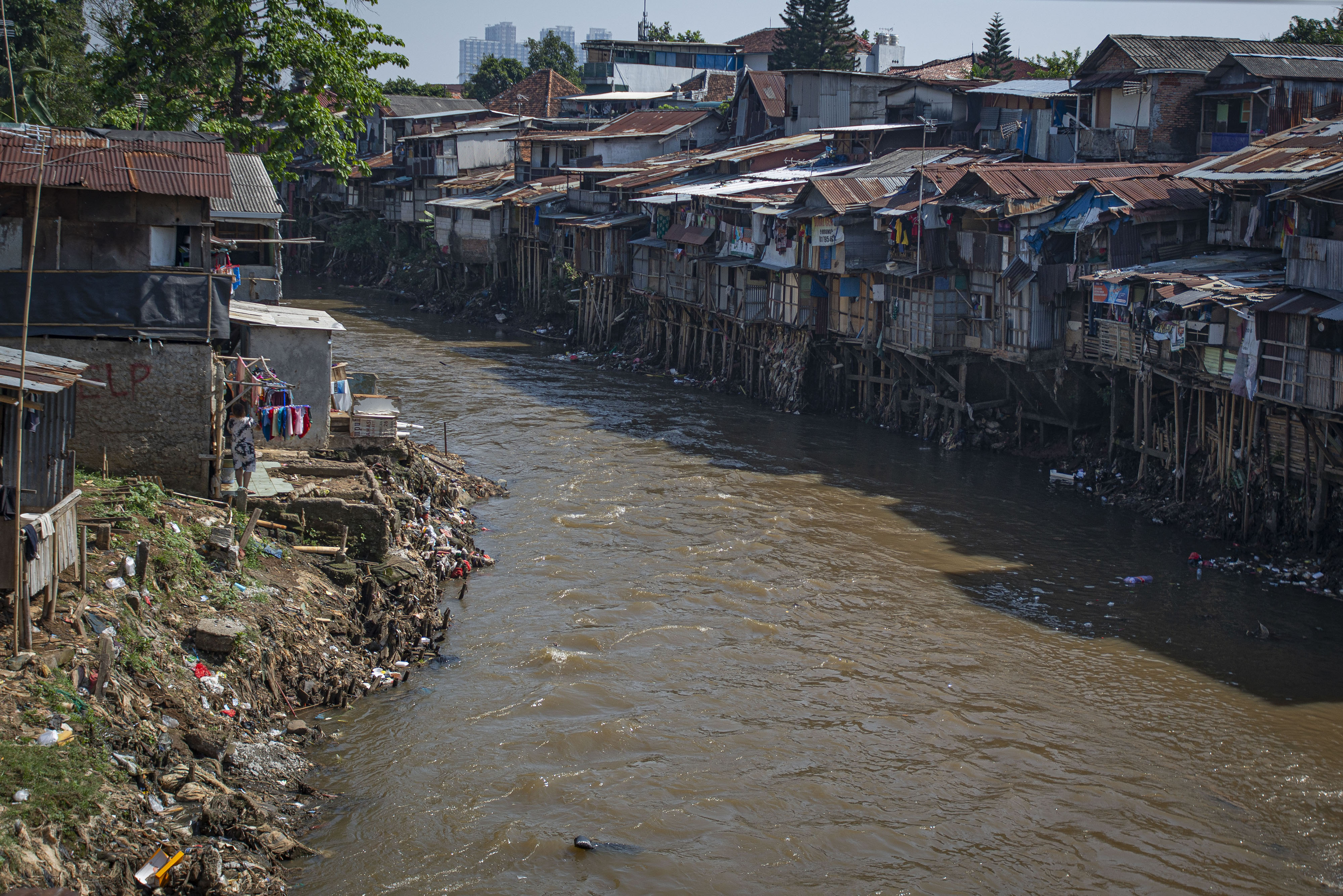  Sejumlah rumah semi permanen berdiri di tepi Sungai Ciliwung, Manggarai, Jakarta, Selasa (27/7/2021)